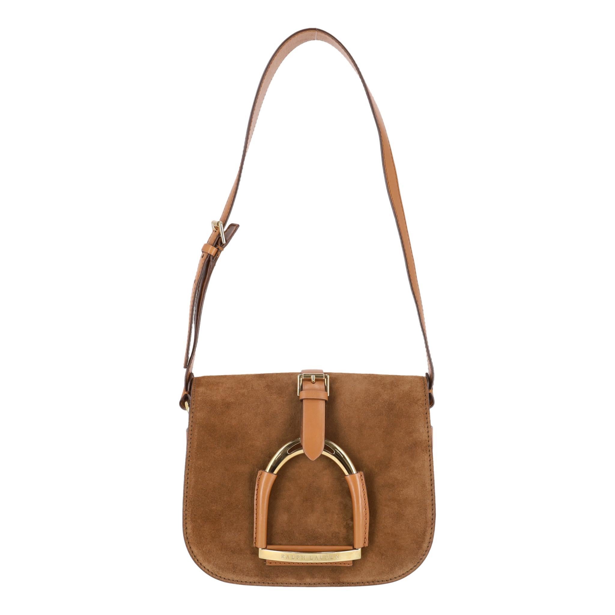 Sacoche en daim Stirrup de Ralph Lauren

Sac en daim marron camel avec cuir beige, bandoulière et bordures réglables.

Le bracelet est orné de la marque Icone et d'un emblème en forme d'étrier sur le devant.

Le rabat avant permet d'accéder à un