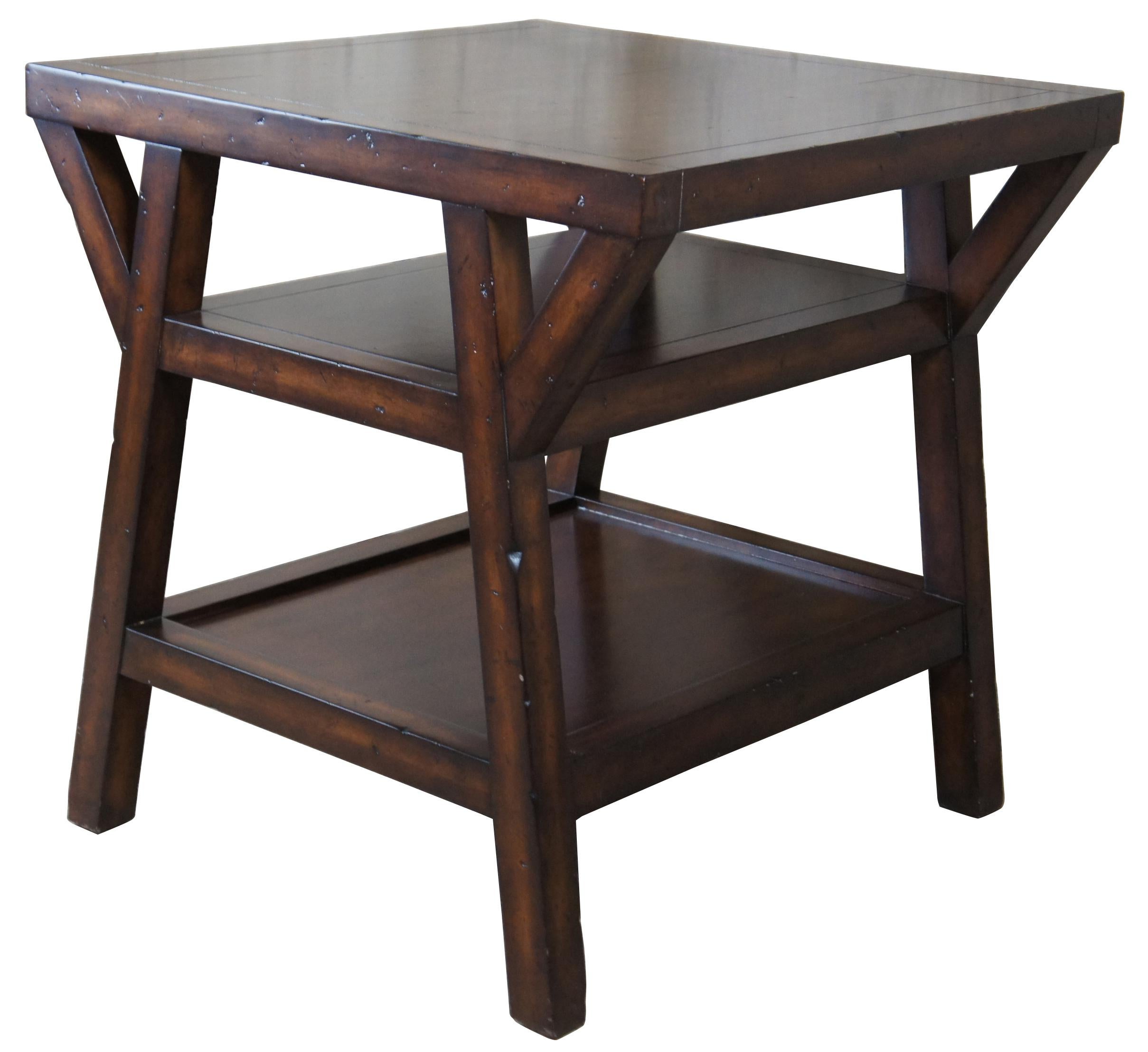 Square tiered side table by Lauren Ralph Lauren. Made from mahogany with a naturally distressed finish. Features a three tiered design with paneled top and inset lower shelf. Measures: 30”.
   