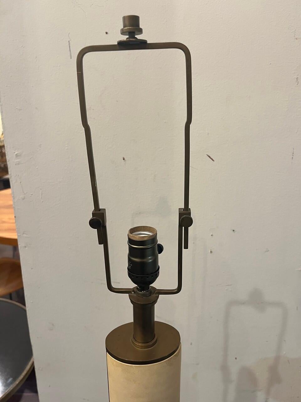 The upper fifth floor lamp by Ralph Lauren Home, circa 2000.

Featuring a parchment leather covered stem on a natural brass round base.  These lamps were originally topped with a silk shade.

Bulb: 3-way bulb wired for US.  Wiring is new.  Extra