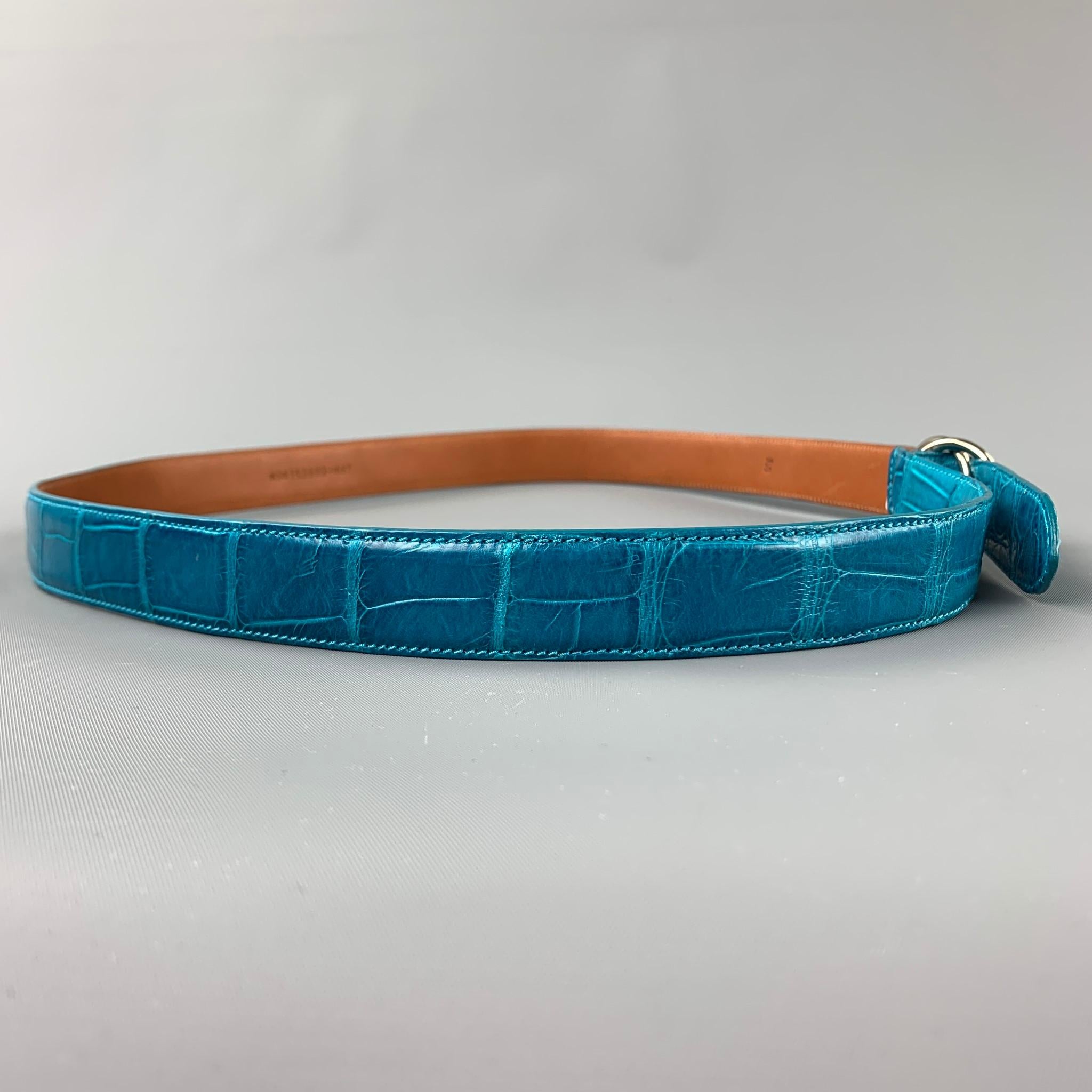 RALPH LAURE belt comes in a turquoise alligator featuring a silver tone double ring closure. Made in Italy.

Very Good Pre-Owned Condition.
Marked: M

Length: 43 in.
Width: 1 in.