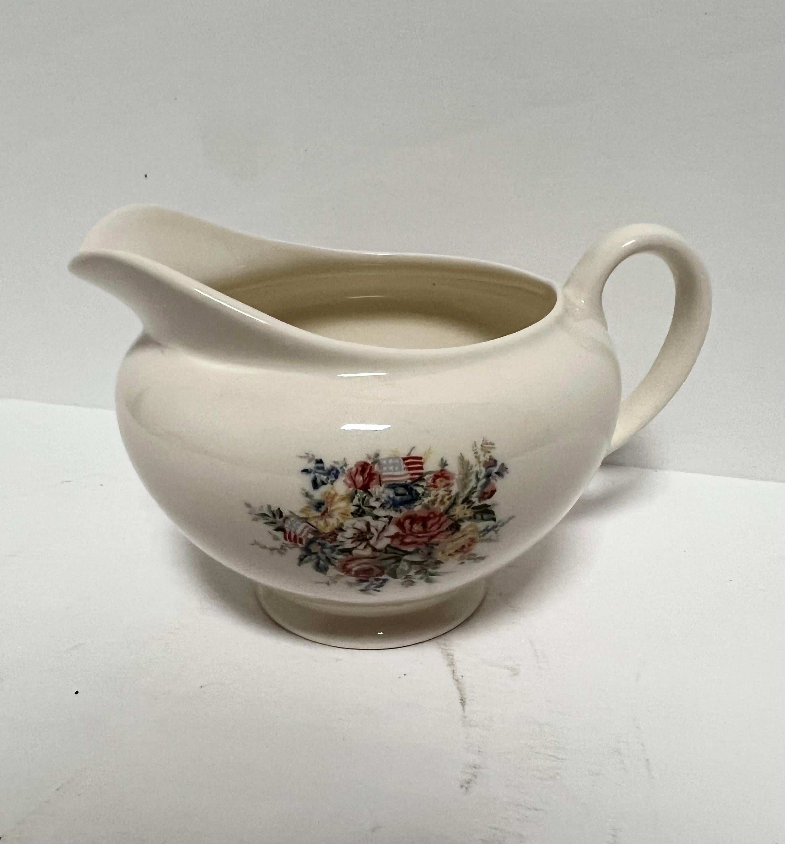 Creamer by Wedgwood for Ralph Lauren Home in the
Dylans Grove pattern.

Made in England. Discontinued; actual production period: 1993 - 1996.

Signed.

Design features Floral Center and American Flags complemented by Blue Band.

Very good/pre-owned