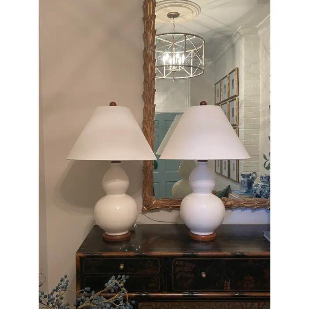 Beautiful pair of white glazed ceramic Lauren Ralph Lauren table lamps with white canvas shades, double gourd bodies and brand plaque at wooden bases. Tested for working order.
Measurements: Lamp- Height 26