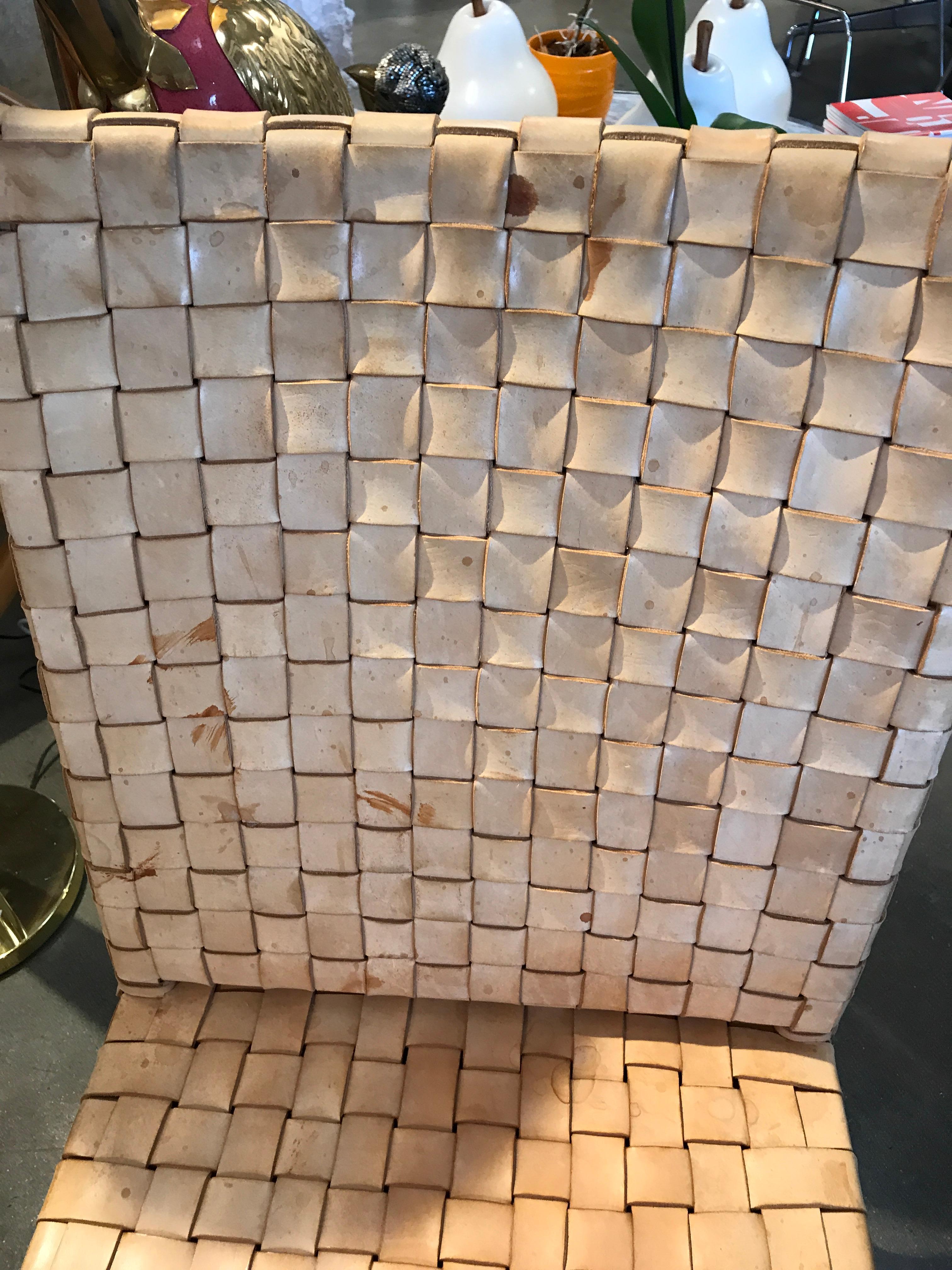 A nicely made woven thick leather strip chair sold by Ralph Lauren. The leather has some discoloration and the legs have been retouched. The leather has scuffs and signs of use. Nicely made with a tacked duvet bottom.