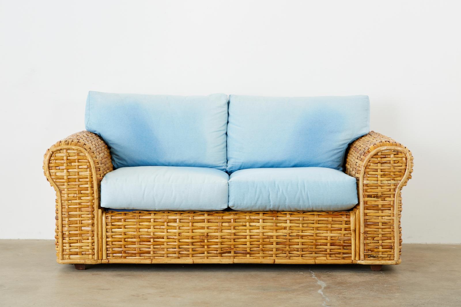 Distinctive settee or loveseat by Ralph Lauren Polo collection constructed from woven bamboo rattan reeds. Features a blue ombre faded soft denim style cotton fabric that has a lovely age and color. Made in the organic modern style of the late 20th