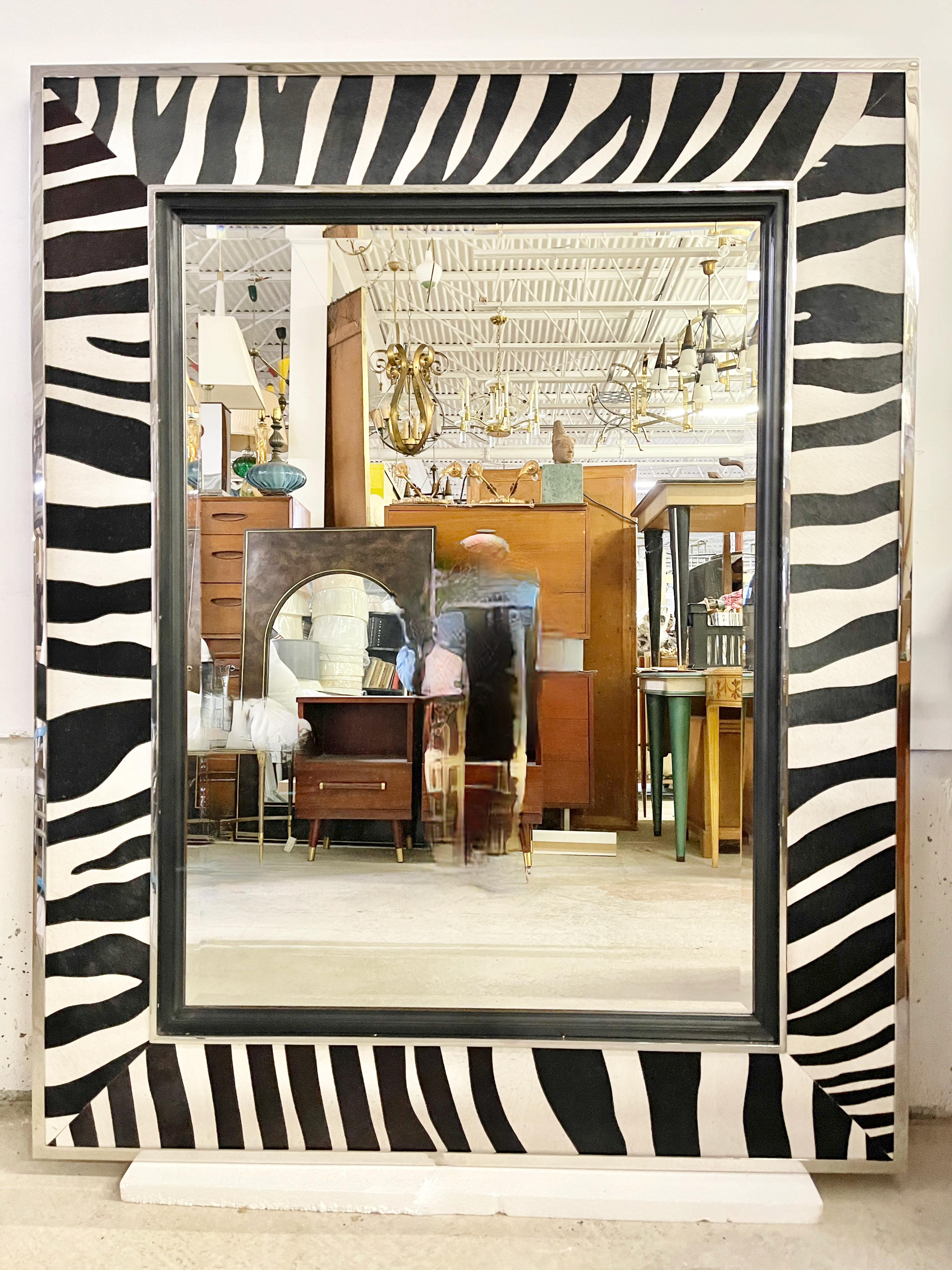 Extra large exotic modernist beveled glass wall mirror set within outer and inner frame of brightly polished nickel plated steel, featuring faux zebra dyed cowhide and ebonized mahogany inner frame
Ralph Lauren embossed metal tag on
