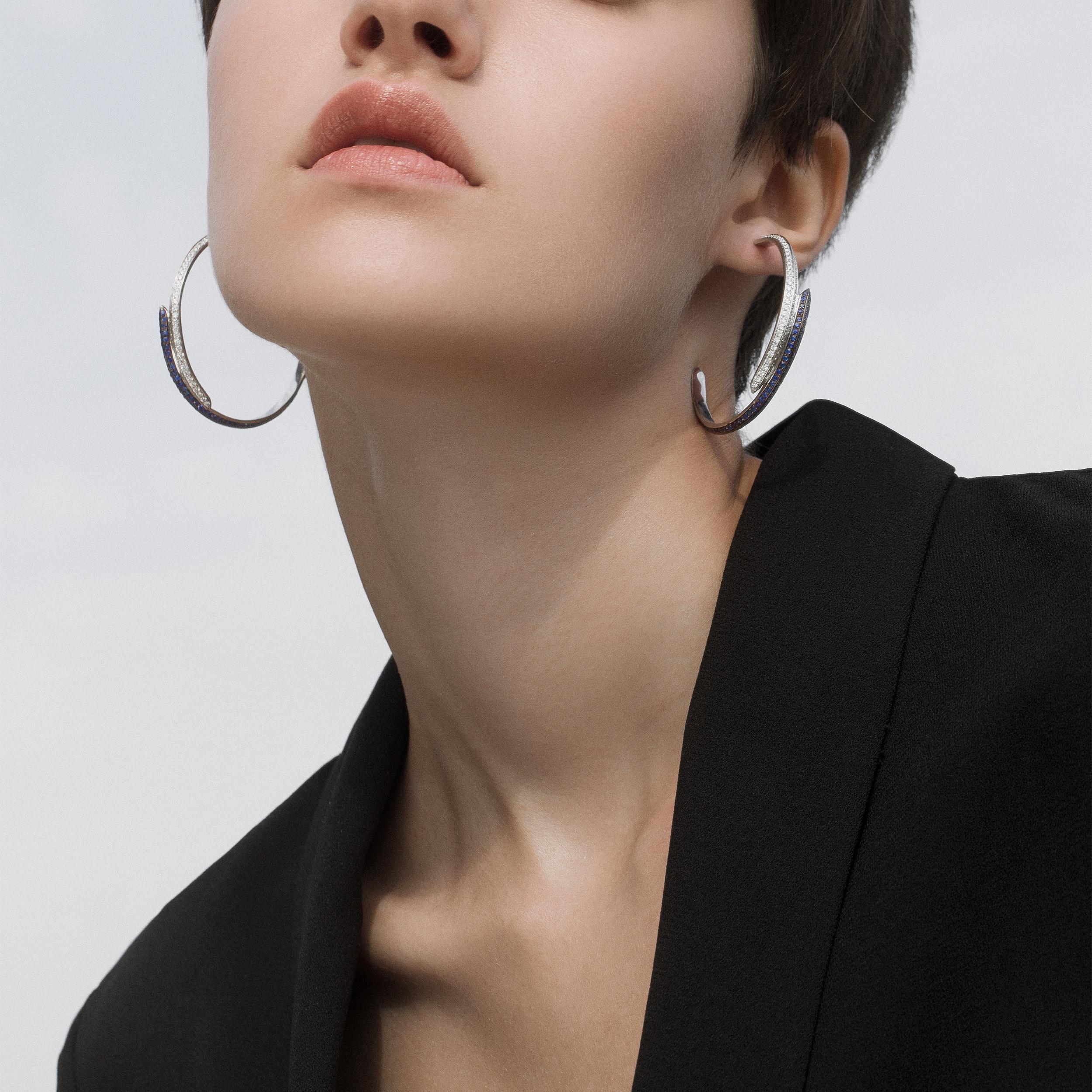 18kt white gold hoops with diamonds and sapphires from Ralph Masri's Modernist collection, inspired by mid-century Modernist architecture with an emphasis on minimalist shapes and silhouettes.

Available in yellow, rose or white gold.

Push backs
