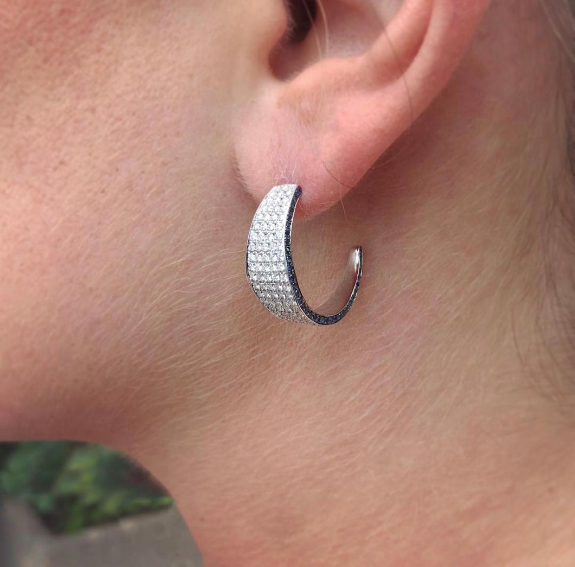 Eleganti cerchi in oro bianco 18kt con diamanti e zaffiri blu della collezione Modernist di Ralph Masri, ispirata all'architettura modernista di metà secolo con un'enfasi su forme e silhouette minimaliste.

Disponibile in oro giallo, rosa o