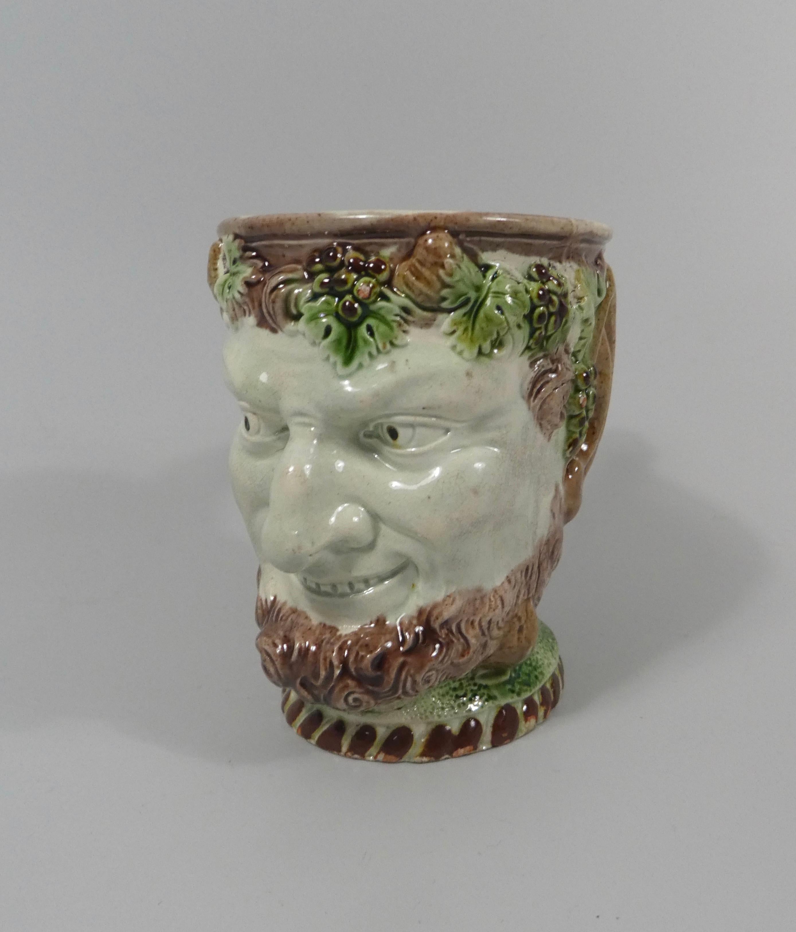 A fine Ralph Wood, Staffordshire creamware mug, circa 1770. The mug taking the form of the head of Bacchus, beneath carefully applied colored glazes. The details are finely defined in this early example, with grapes and vine issuing from the branch