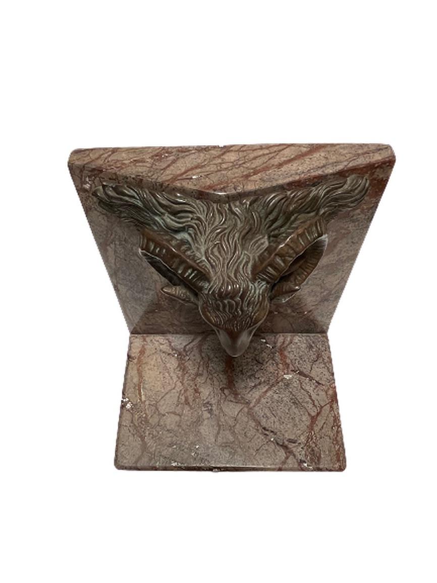 A pair of heavy marble bookends featuring a bronze ram's head designed by Theodore and Alexander. These sculptural pieces are perfect for any room and weigh over 10lbs apiece. Each ram's head has a wonderful patina from the natural aging process of