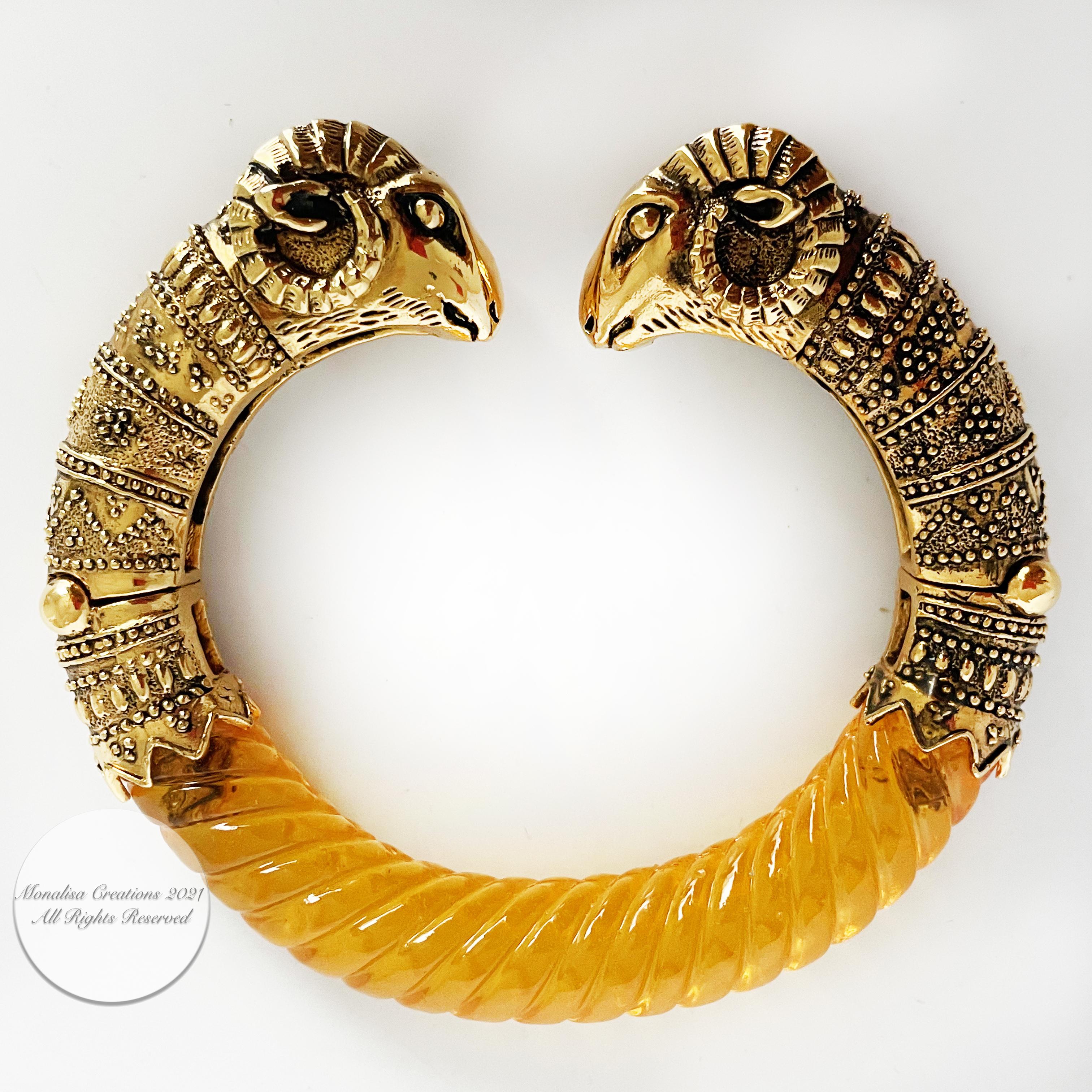 Incredibly beautiful double rams head bracelet, likely made in the 70s.  Made from gold metal and an amber-hued resin, the detailing on this piece is exquisite.  Clamper style, with articulation at the base of each ram head.  No manufacturer stamp