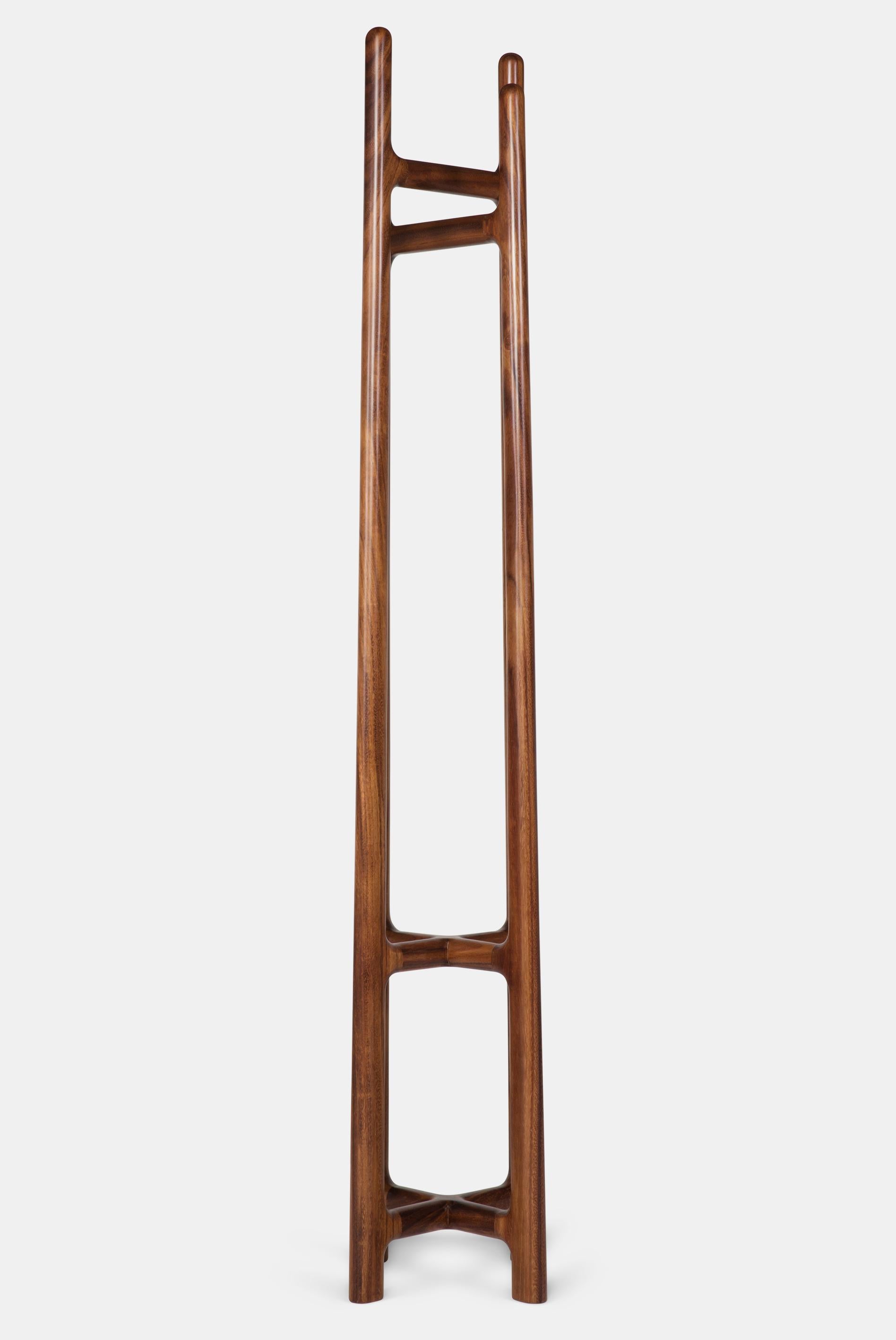Dieser Standgarderobenständer hat einen kontrastierenden Schnittpunkt zwischen seinen 4 Beinen, der ein einzigartiges und dynamisches Aussehen erzeugt, das in Kombination mit hochwertigem, massivem Hartholz einen unverwechselbaren, eleganten Ständer