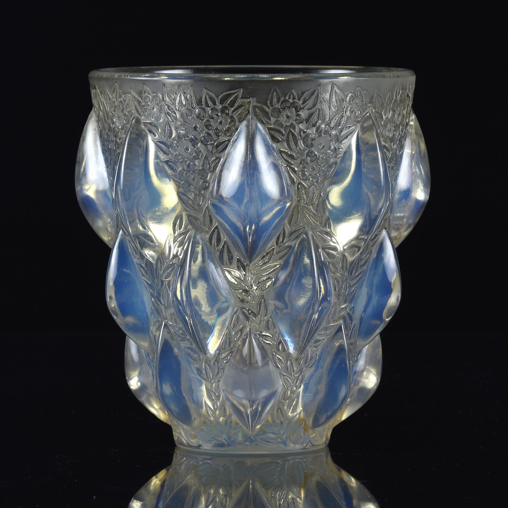 Vaso in vetro Art Deco trasparente, smerigliato e opalescente con motivo a losanghe in rilievo intervallato da rami fioriti accentuati da leggere macchie, firmato alla base R Lalique France
 
Rampillon
Numero di catalogo: 991
Identificazione