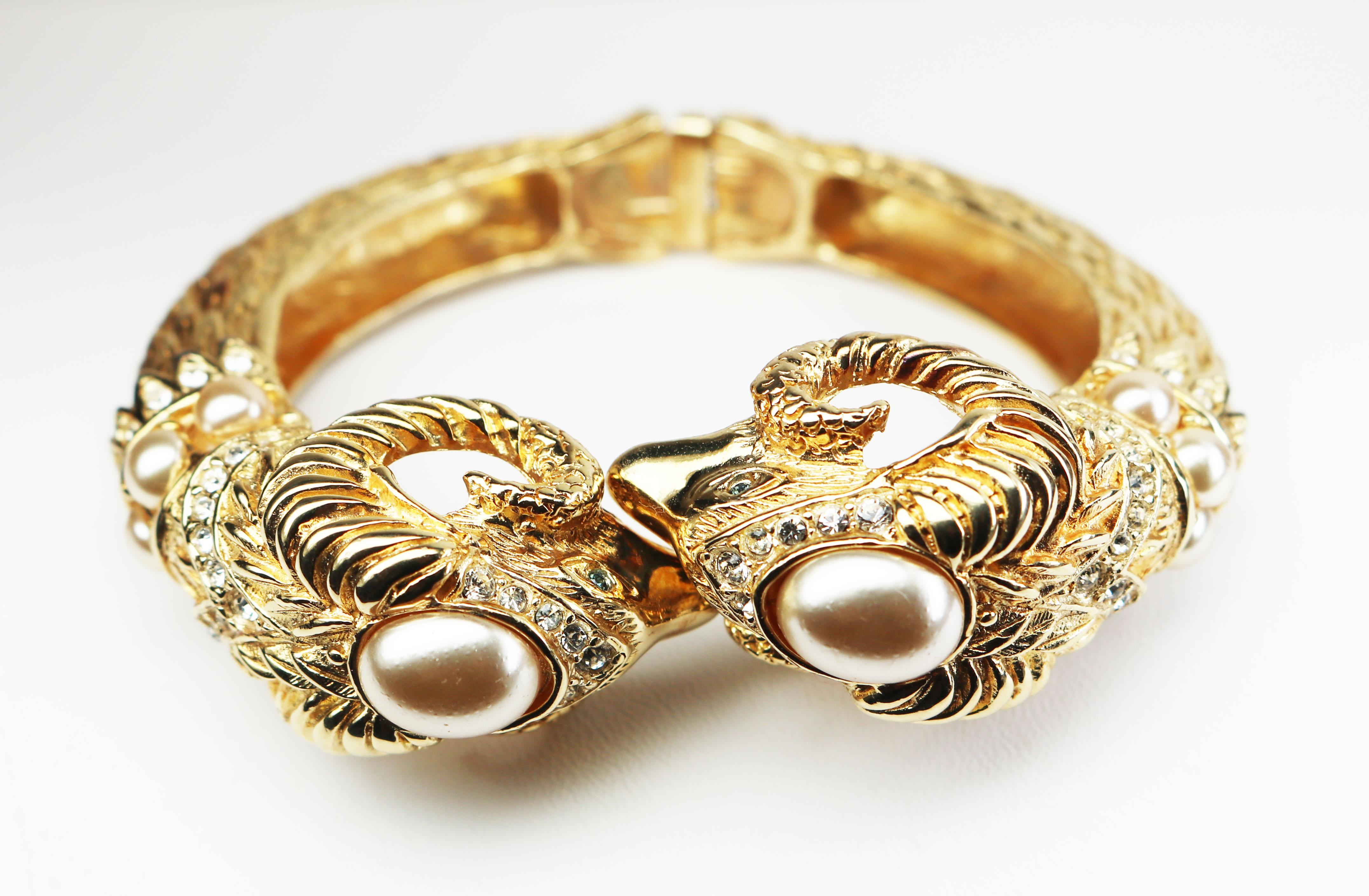 This highly collectible bracelet features two matching sculptured, gold plated ram’s heads with simulated pearl embellishments and encrusted with clear rhinestones and four stunning green rhinestone eyes. You’ll find this piece truly breathtaking!