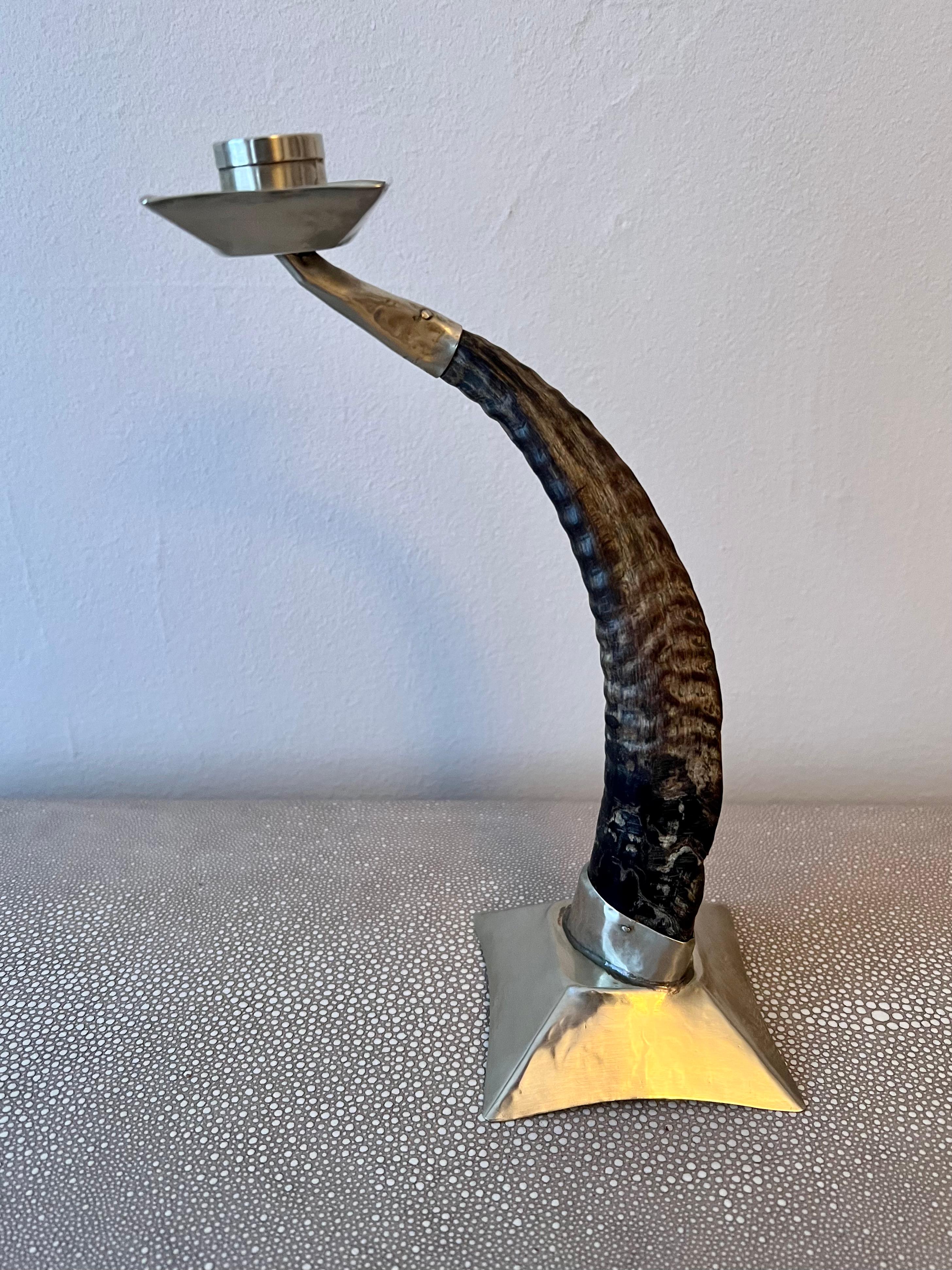 Candle stick holder made of ram's horn with silver base and candle cup. This is a vintage piece with good character and holds a standard size taper candle with style and ease.