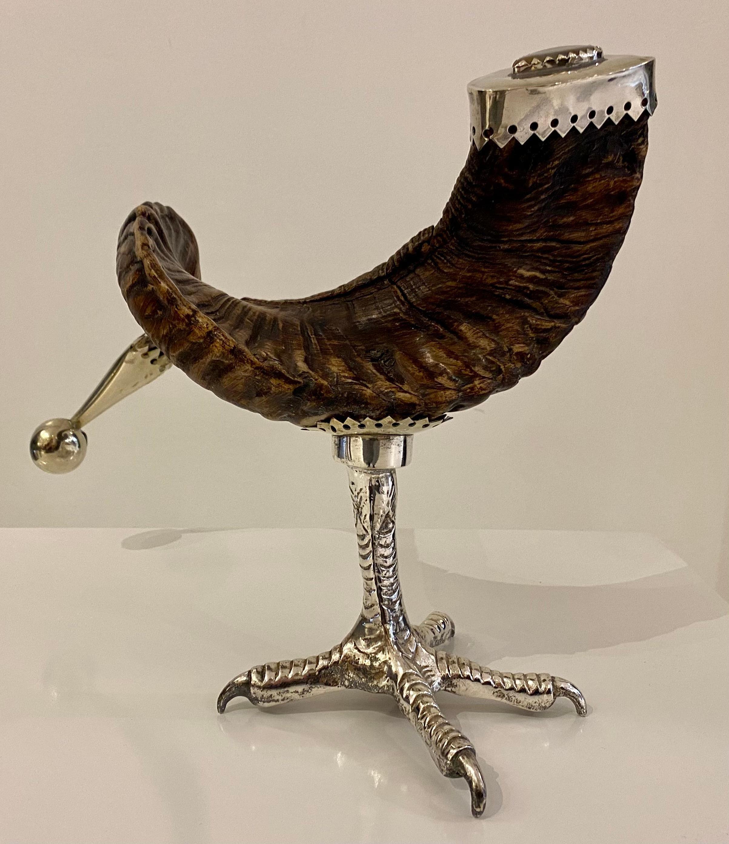 This is an impressive cast resin ram's horn sculpture by Anthony Redmile. A ram's horn serves as the primary element of this piece. A silver plated talon supports the sculpture. An ornate nickel fitting holds an agate specimen on the top of the