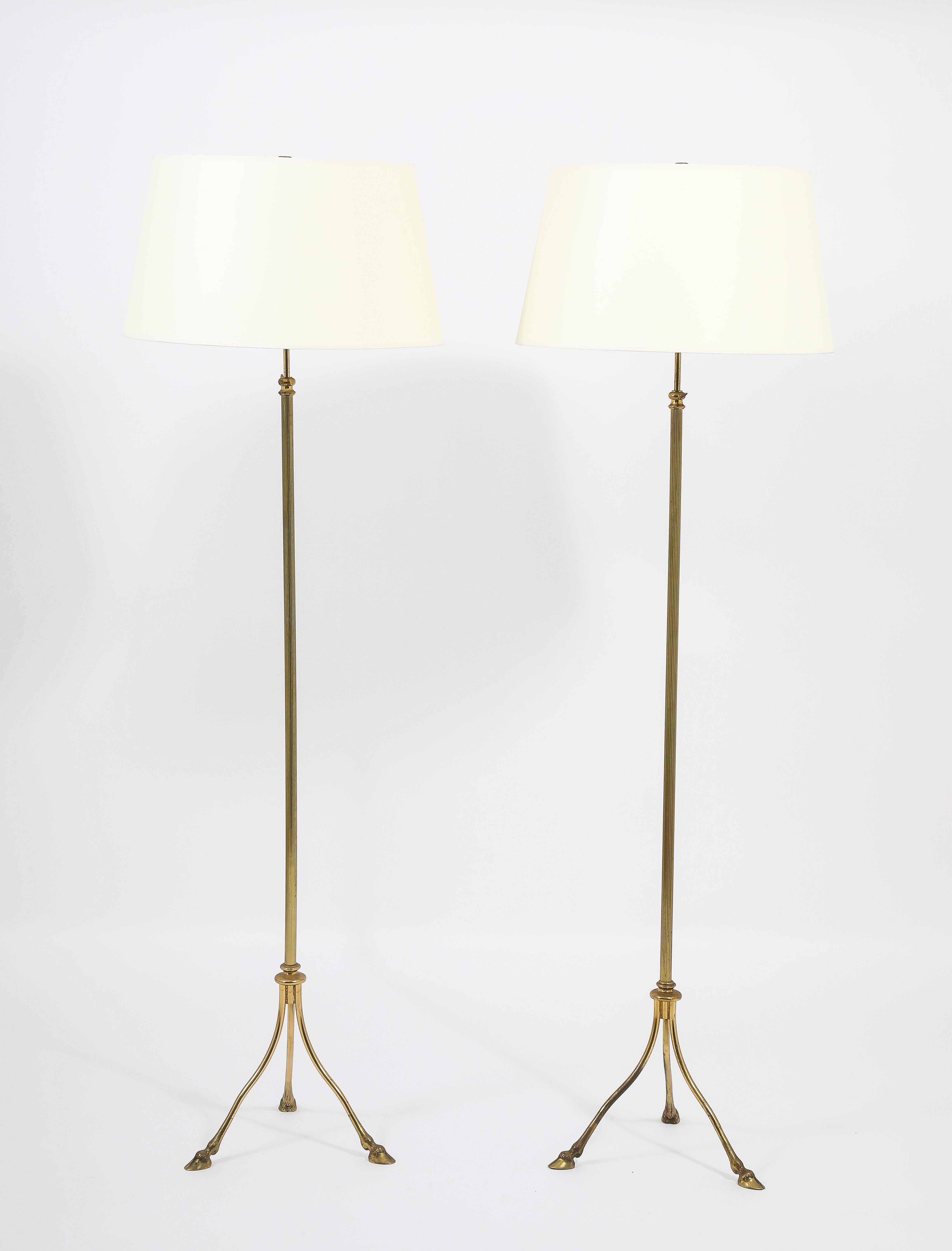 Pair of adjustable floor lamps with a grooved stem on a tripod base ending in hooves. Adjusts to 85