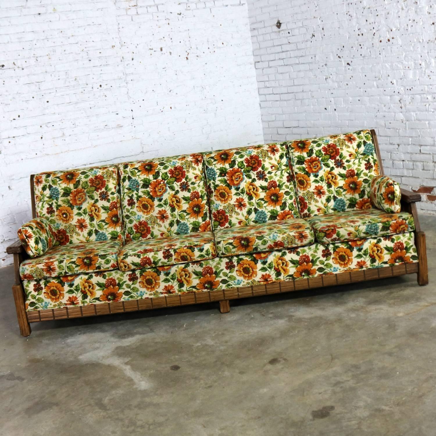 Incredible ranch oak western style sofa attributed to A. Brandt Company. This sofa is in wonderful vintage condition with the original wood finish and wildly floral upholstery. The upholstery fabric is in nice condition and could be used; however,