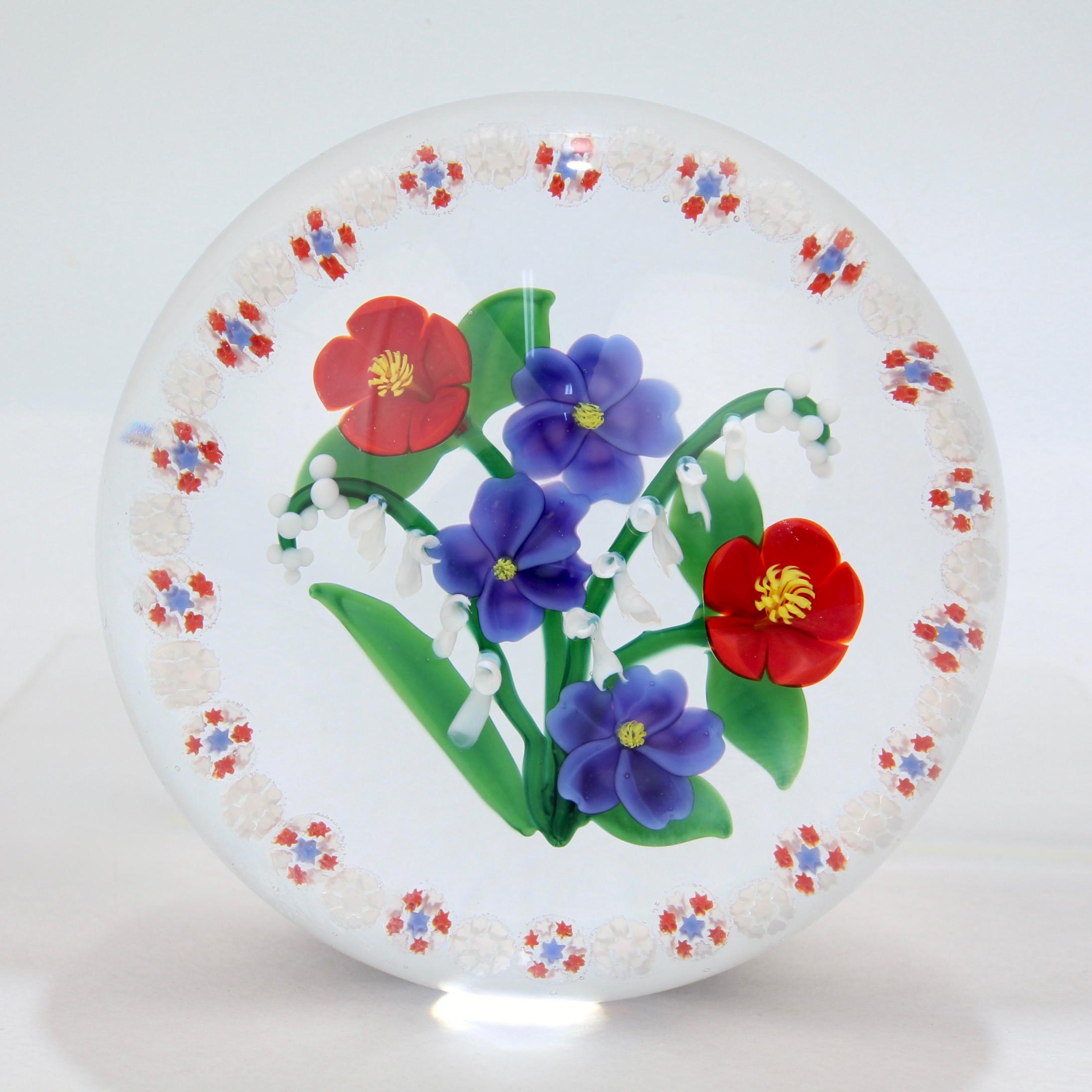 A fine, signed lampwork paperweight by Randall Grubb.

With a flat floral bouquet surrounded by a millefiori ring or garland.

With a G signature cane at the base of the flowers. 

Signed with an etched signature to the side: Randall Grubb