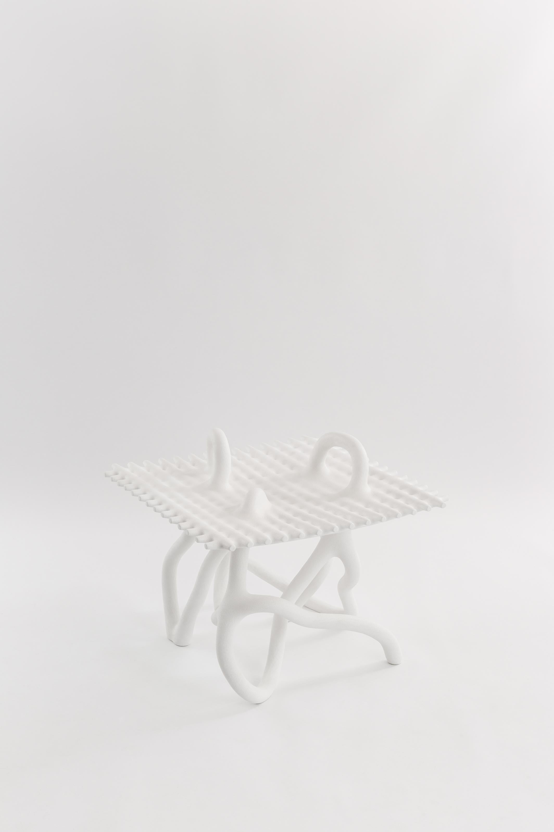 Random table on Grid by HWE
Limited Edition
Materials: Waste SLS 3D nylon powder, sand from sustainable sources
Dimensions: L 65 x W 65 x H 60 cm 
Colour: white

Hot Wire Extensions is a young sustainable design brand, presenting a bold innovative
