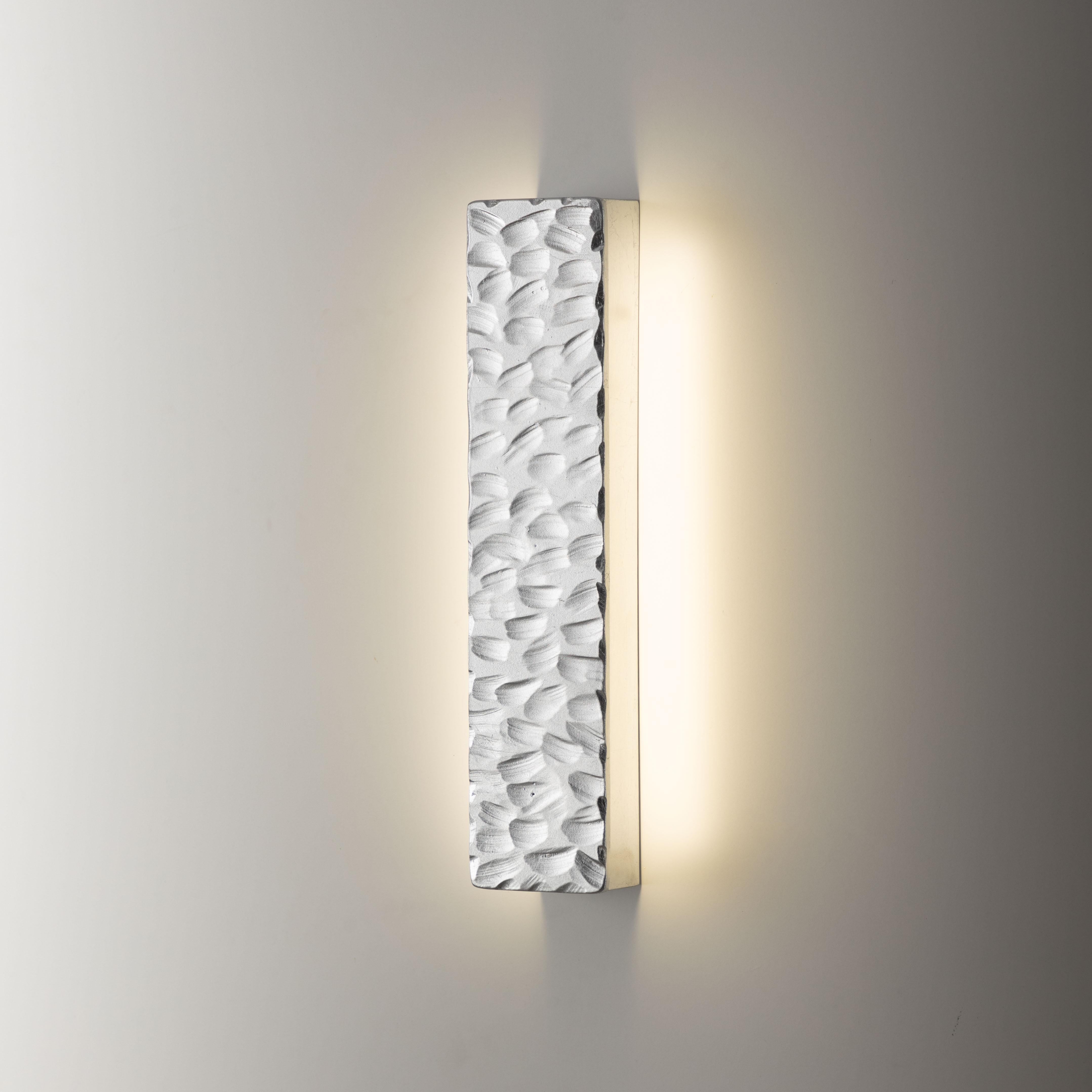 Lampada da parete Random, 21652, di Stillux Illuminazione
Dimensioni: D 4,5 x L 7 x H 30 cm.
Materiali: Acciaio, ferro, foglia d'argento.

Disponibile in foglia d'oro, foglia d'argento, foglia d'oro anticato, argento anticato o nero velluto.