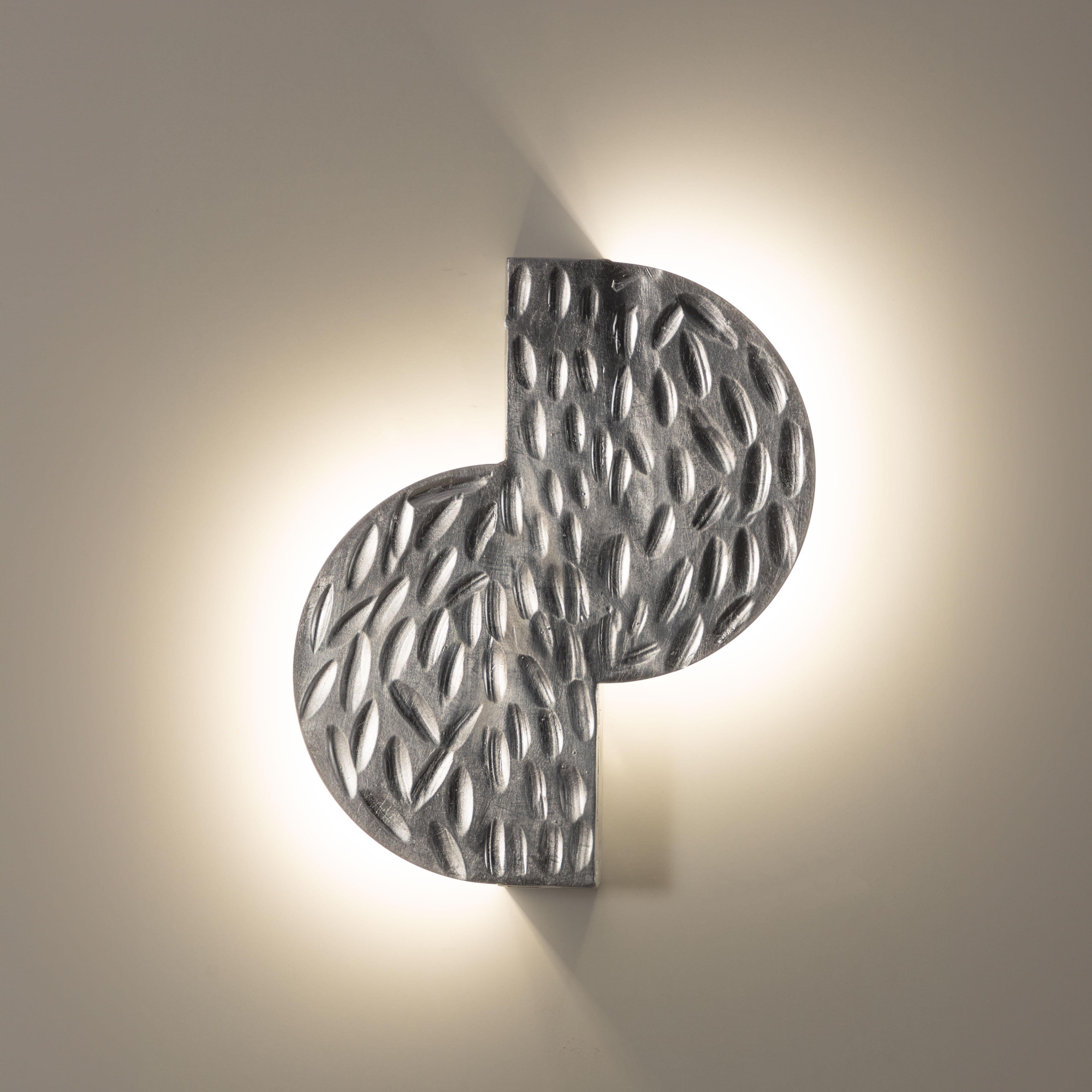Lampada da parete Random, 21654, di Stillux Illuminazione
Dimensioni: D 4,5 x L 21 x H 25 cm.
Materiali: Acciaio, ferro, foglia d'argento.

Disponibile in foglia d'oro, foglia d'argento, foglia d'oro anticato, argento anticato o nero velluto.