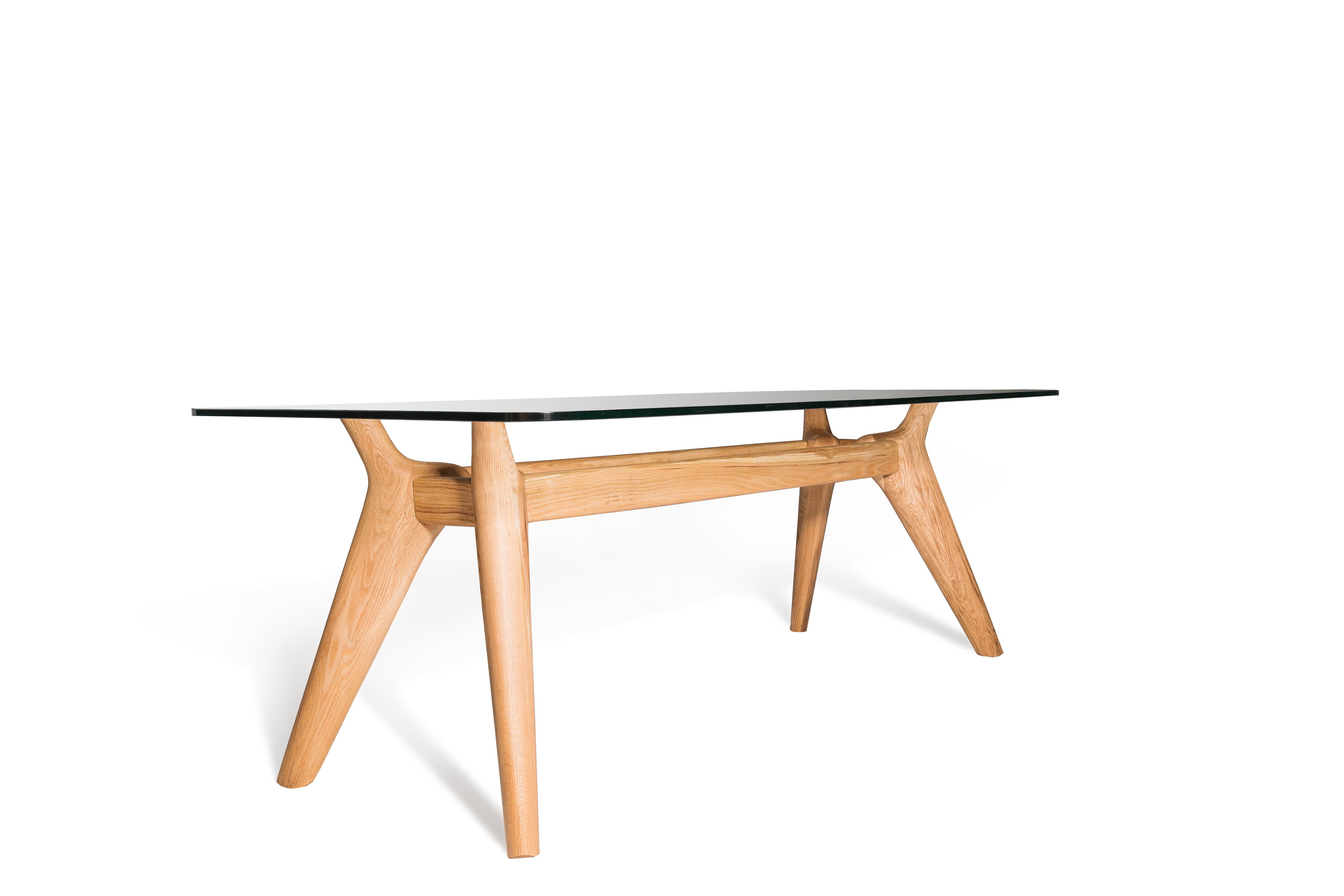 So here’s the story - a table with a true sense of the sculptural, a glass topped table that demonstrates the best of working in solid wood. Available in two lengths to suit dining for six or eight.