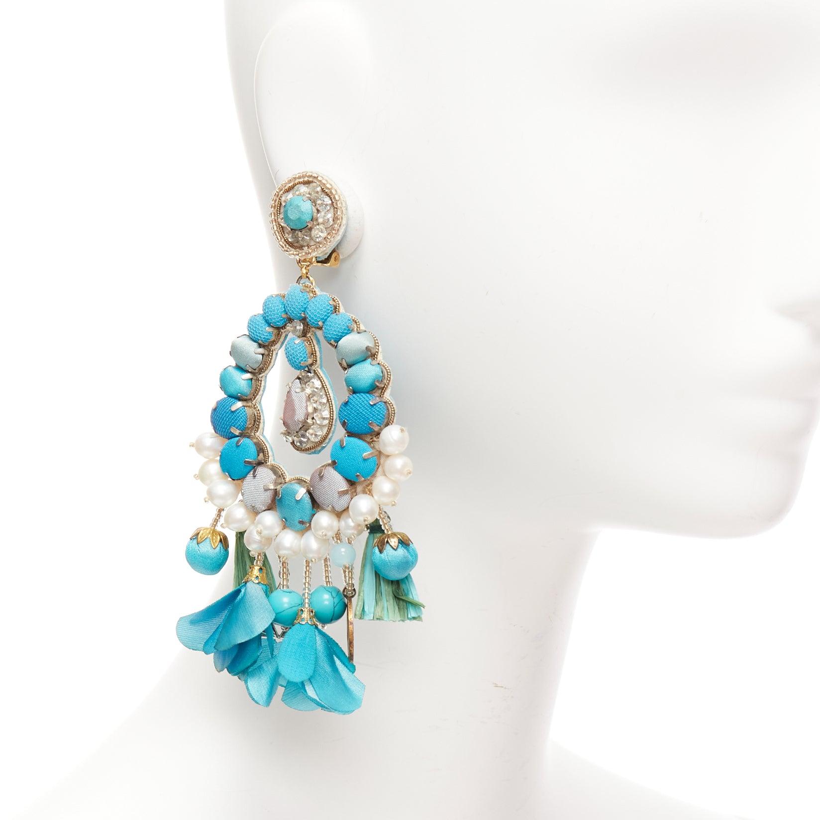 RANJANA KHAN turquoise cream faux pearl stone clip on earrings Pair
Reference: AAWC/A01212
Brand: Ranjana Khan
Material: Metal, Fabric
Color: Green, Cream
Pattern: Solid
Closure: Clip On
Lining: Blue Leather
Extra Details: Green faux petals with