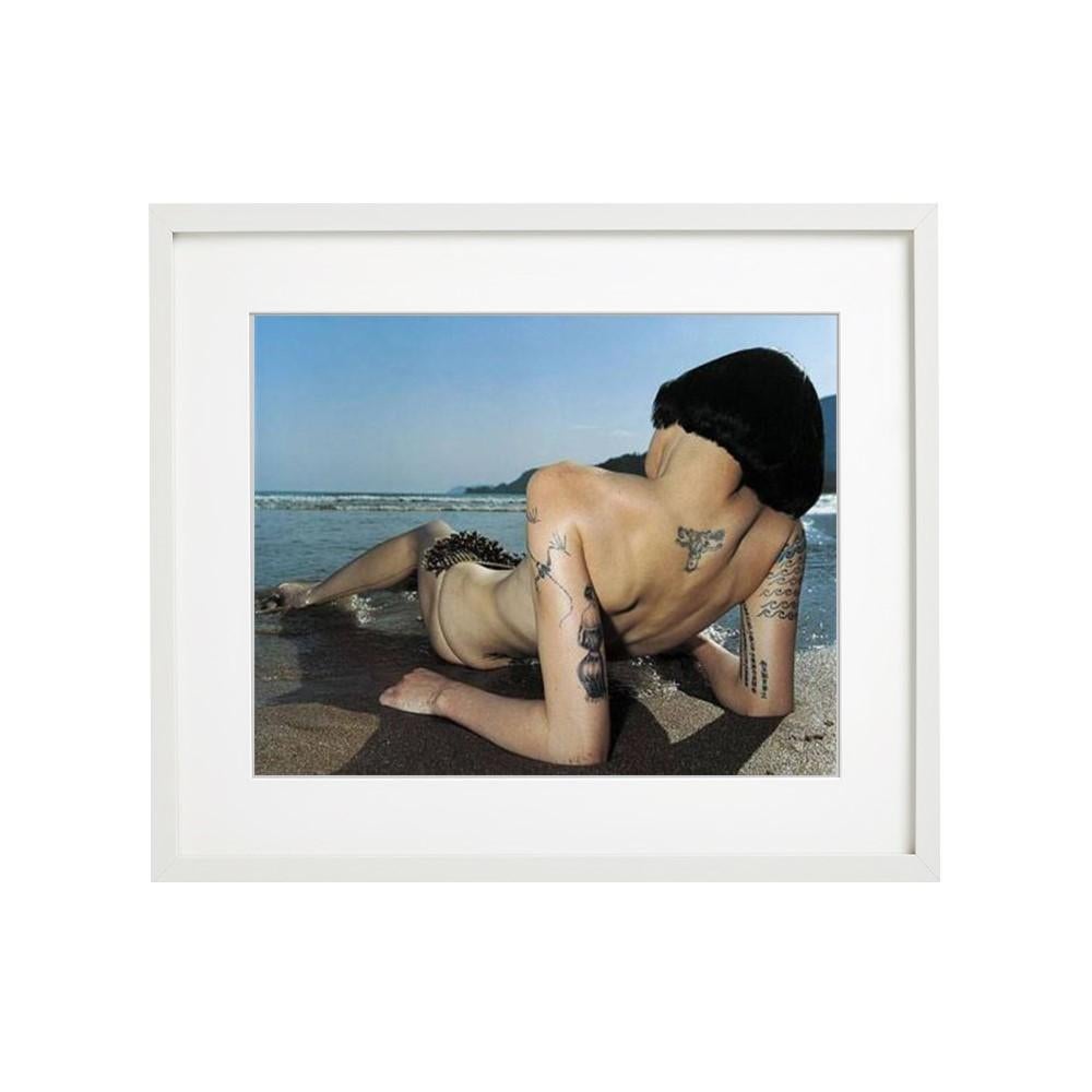 Brazilich-back view of a naked woman with tattoos lying on a beach - Photograph by Rankin
