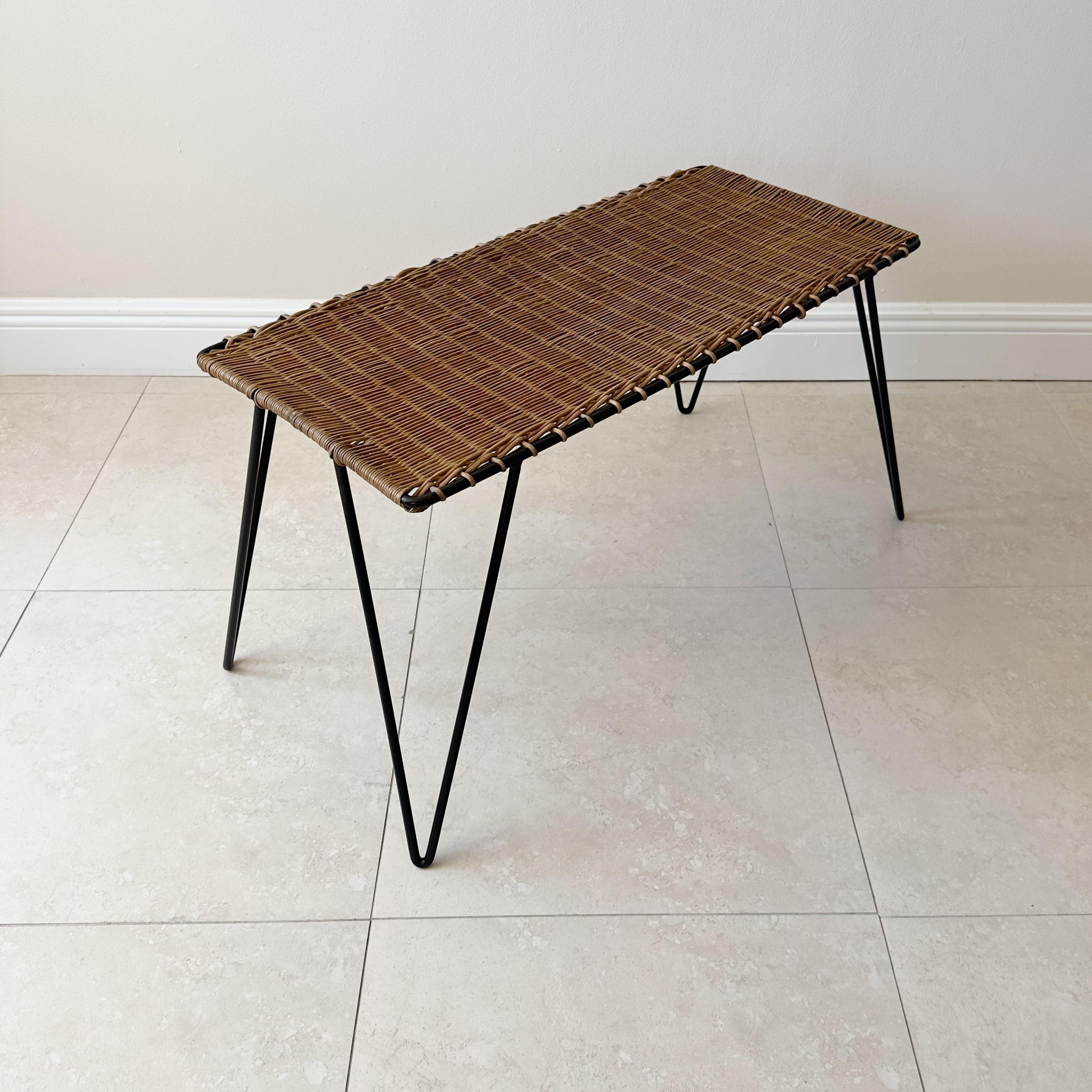 Wicker and painted black iron coffee table by French designer Raoul Guys.
Crafted in France in the 1960's with a charming blend of braided rattan and iron.
Original black paint in excellent vintage condition, with minor signs of wear that enhance
