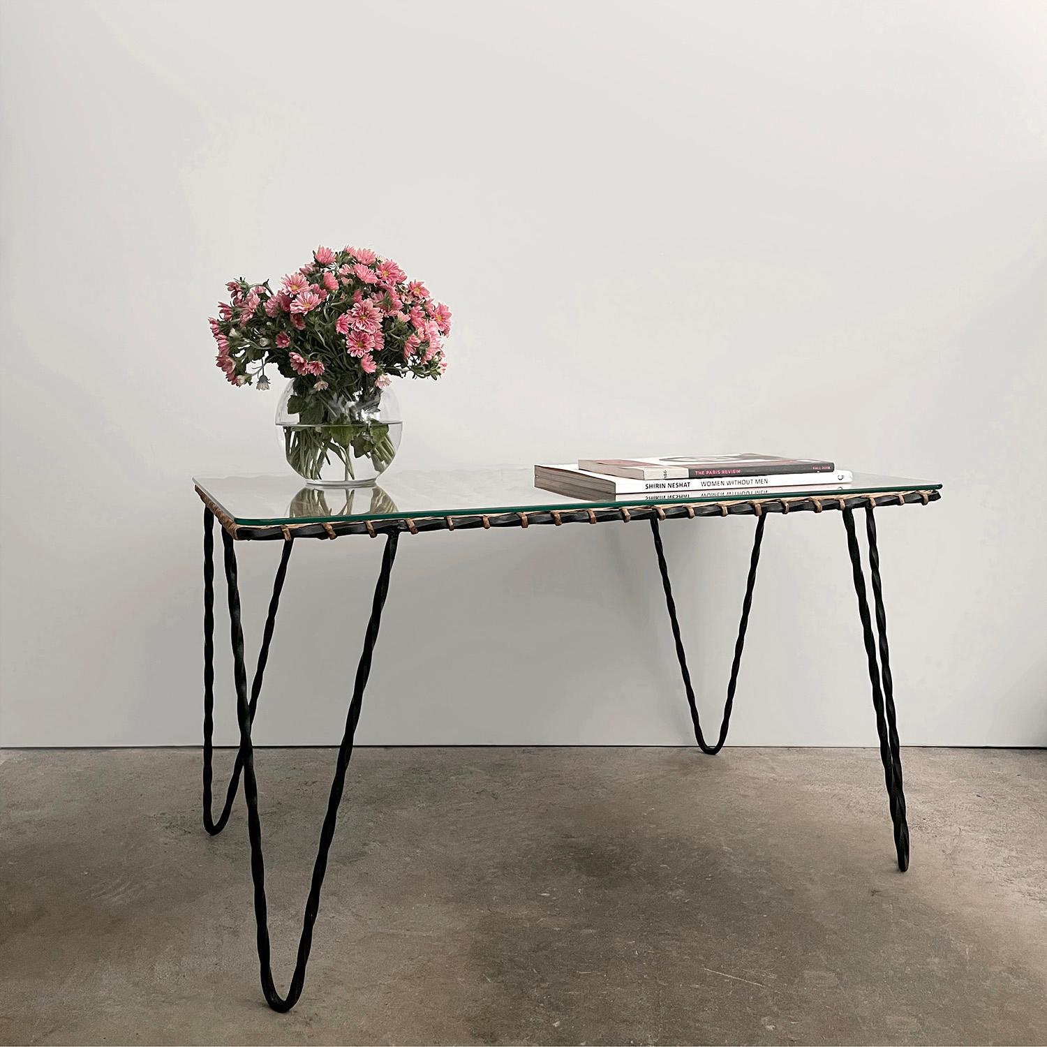 Table basse en osier et fer de Raoul Guys
France, années 1950
Pièce artisanale fabriquée à la main
Le cadre de la table en fer massif est recouvert d'osier tressé de façon complexe.
Variations naturelles dans l'ensemble de l'osier
Les pieds en fer