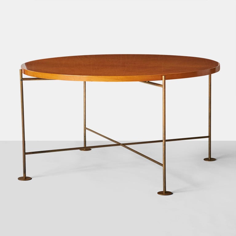 A coffee table by Raphael with X-base stretchers, France, circa 1956, made of gilded brass, birch, Lit.: G. Bloch-Chamfort, Raphael Décorateur, Paris 2002, p. 101.