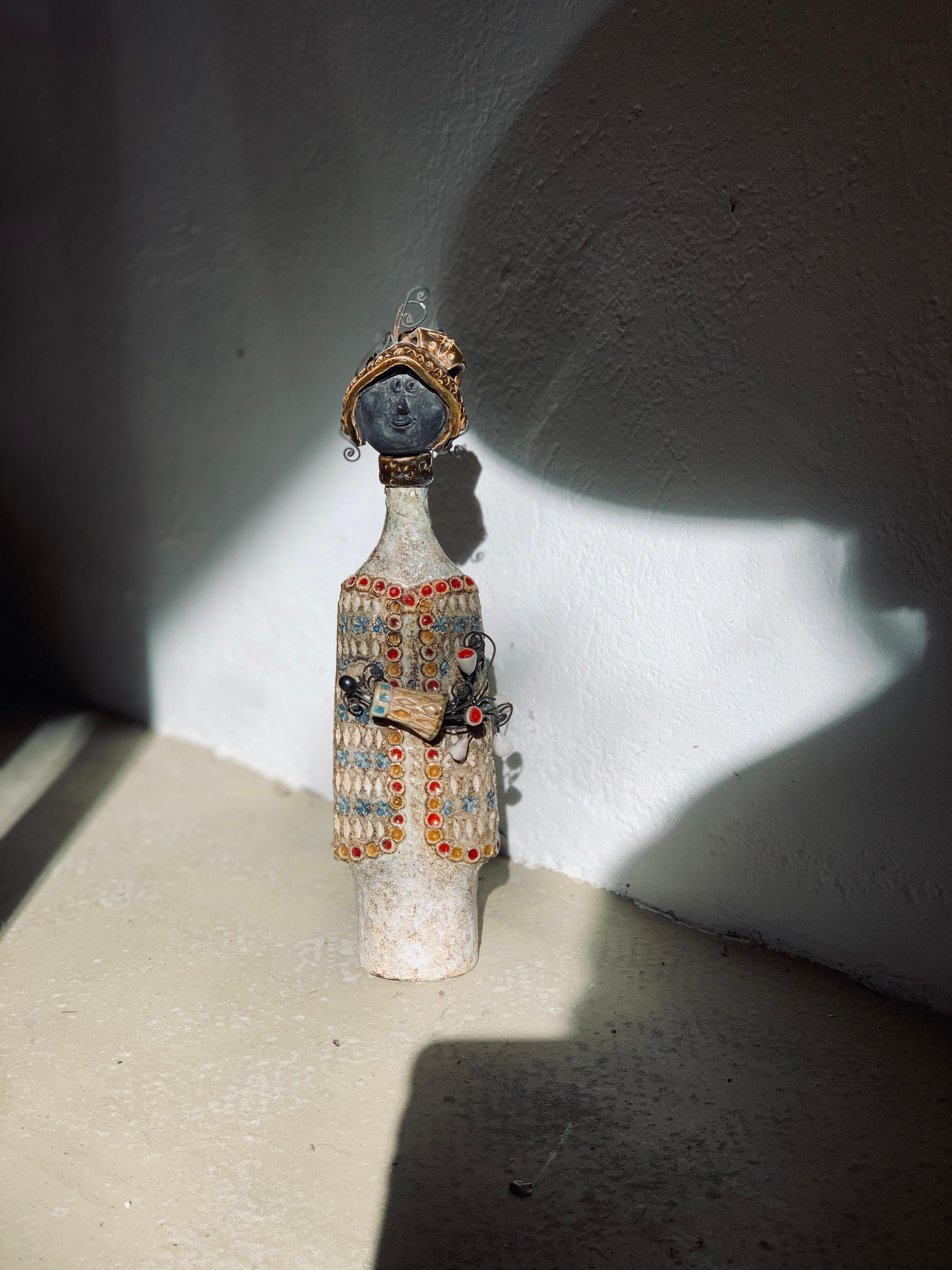 Rare sculpture en céramique émaillée représentant une figure féminine ; l'artiste créait principalement des sculptures de soldats.

Toujours empreintes d'humour et de poésie, les sculptures de Raphaël Giarrusso ont connu un grand succès dans les