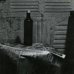 Natura morta con bottiglia e giornale