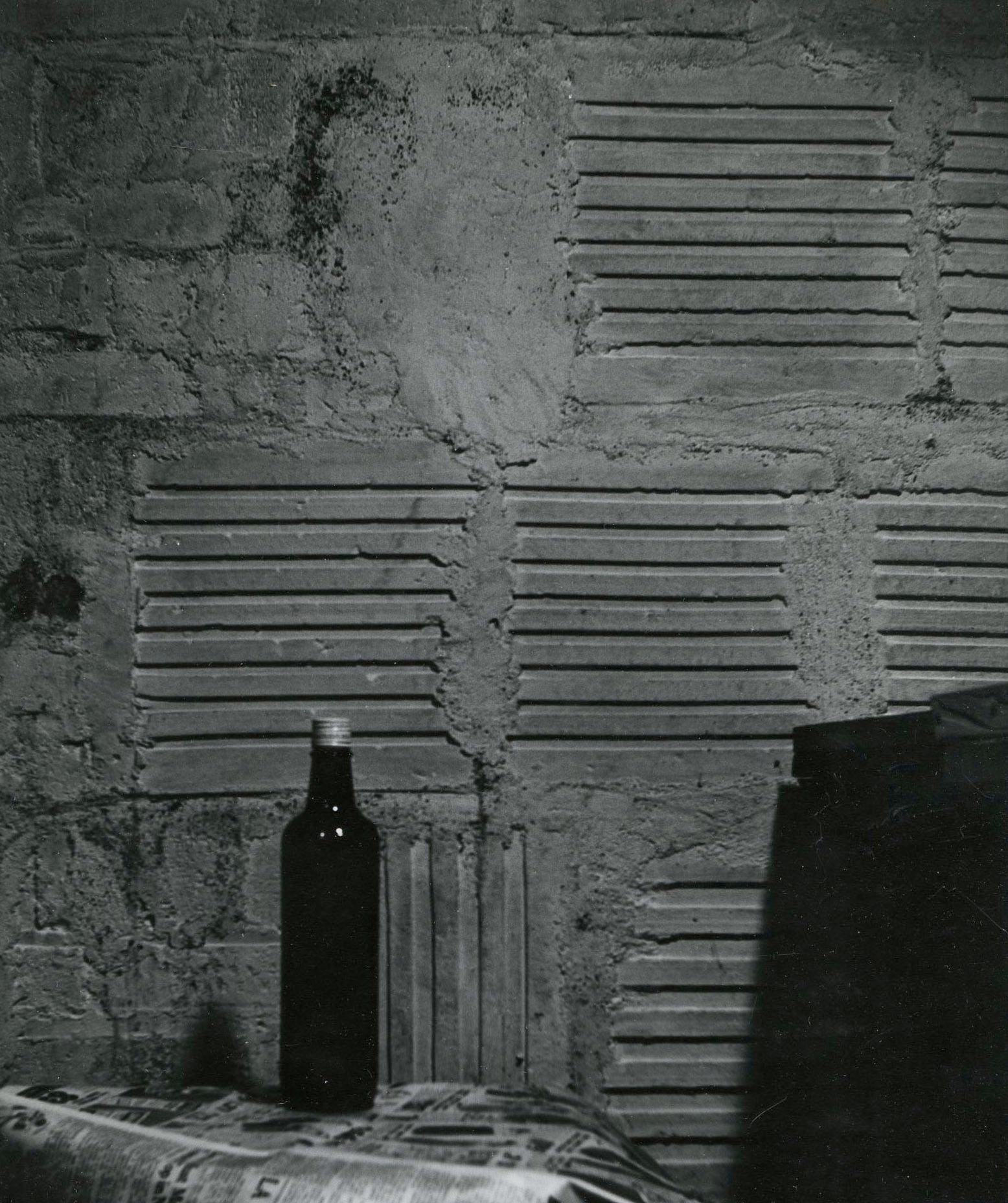 Still Life with bottle and newspaper - Black Still-Life Photograph by Raphael Gleitsman
