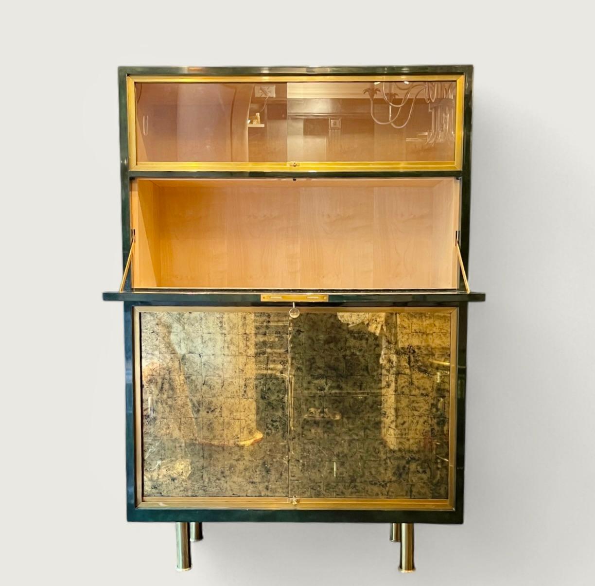 Una rara e  bellissimo bar secco della Maison Raphaël, circa 1950. 
Il mobile è rifinito con la sua caratteristica laccatura Béka verde scuro sulla parte anteriore e laccatura nera sui lati e sul piano. Ci sono  due porte scorrevoli in vetro nella