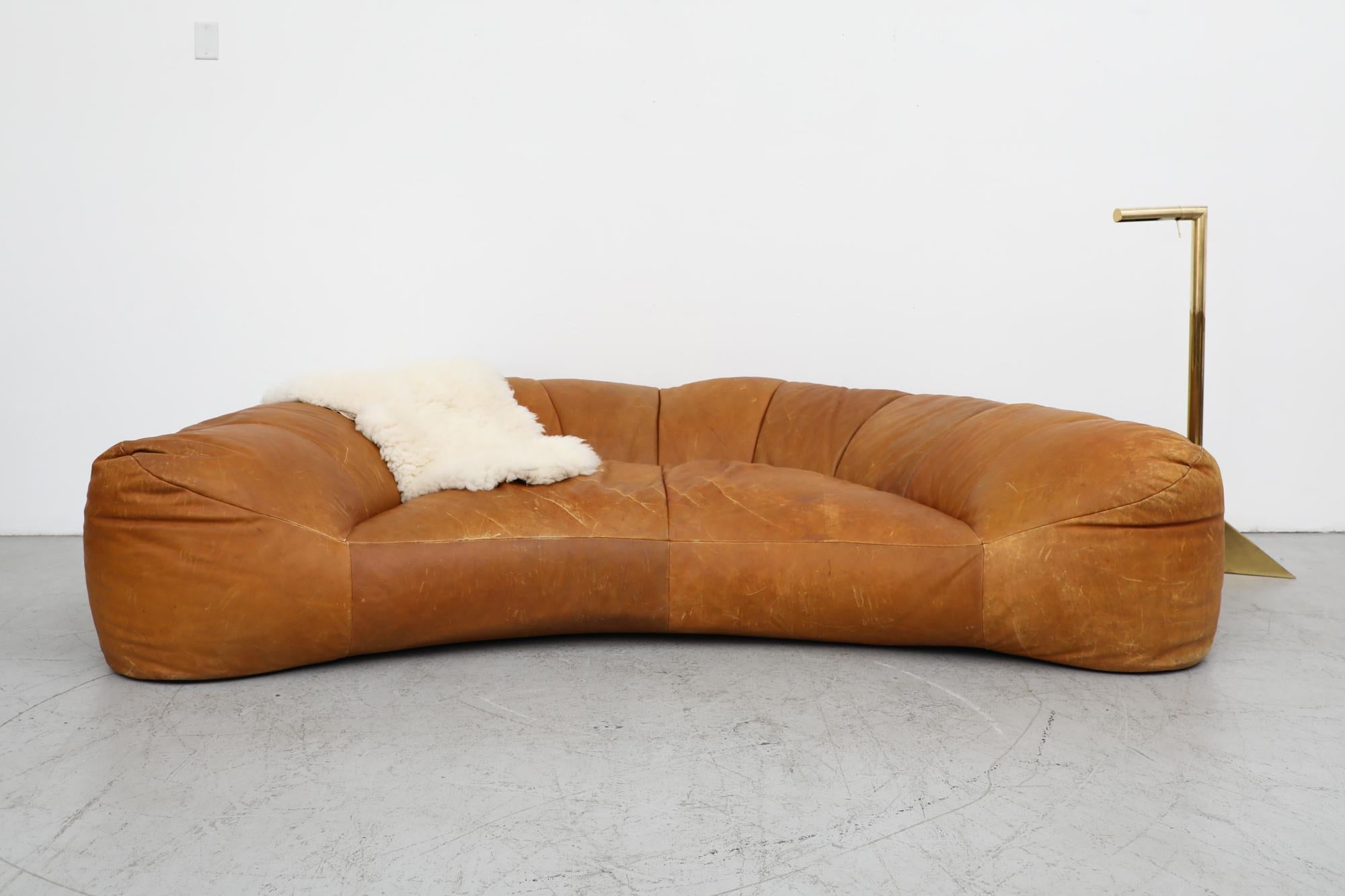 A Mid century, Raphael Raffel designed, 1970's, beautiful cognac leather Croissant Sofa for Honore Paris. Raphael Raffel (1912-2000), who trained at the École des Beaux Arts, was a well-known interior decorator whose work was collected by the likes