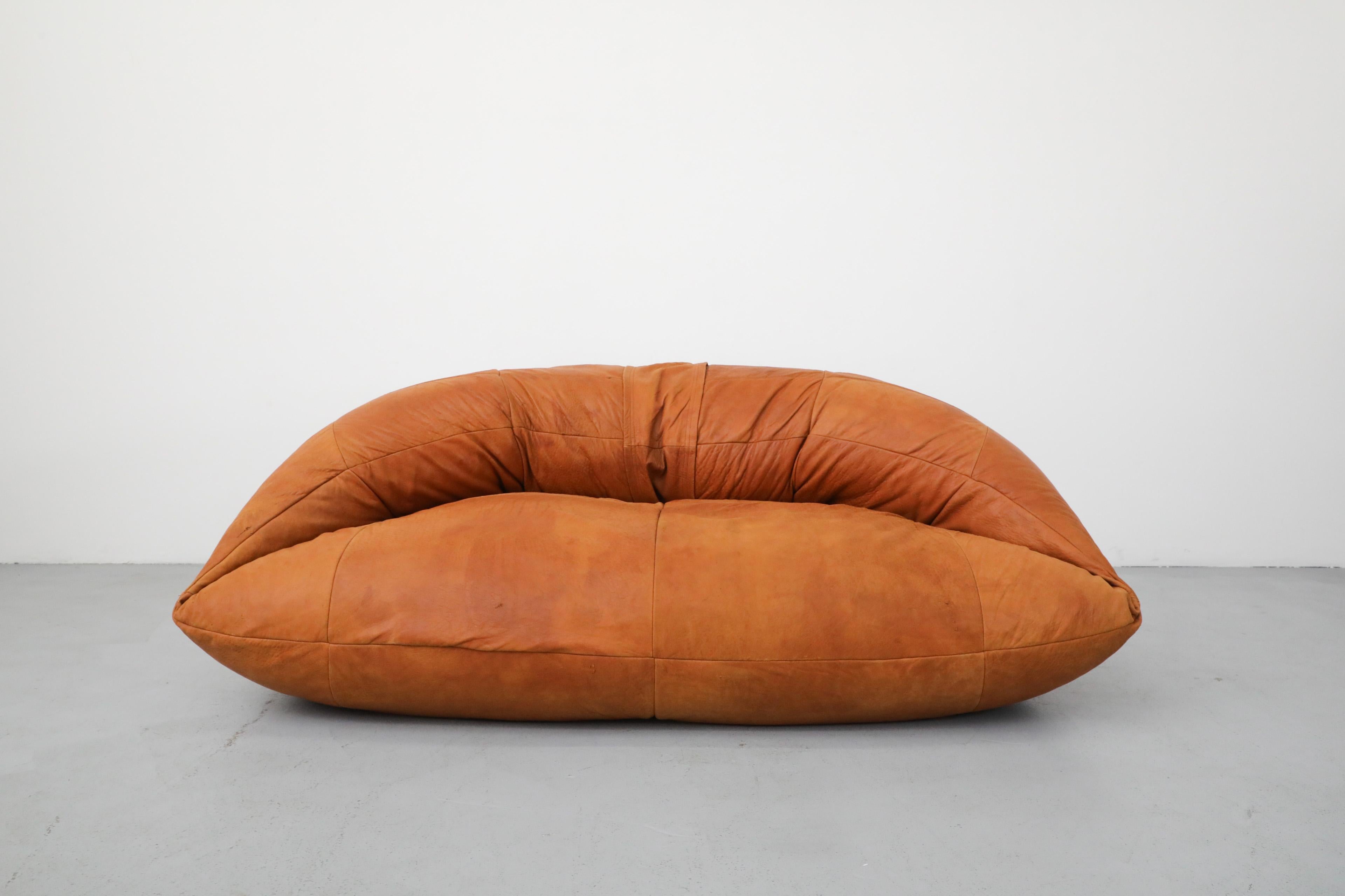 Raphael Raffel cognac leather mini Croissant sofa for Honore Paris, 1970's. This piece is a soft form sofa filled with bean bag material for a comfortable and cozy seat. Innovative and unique French design. In original condition with beautiful
