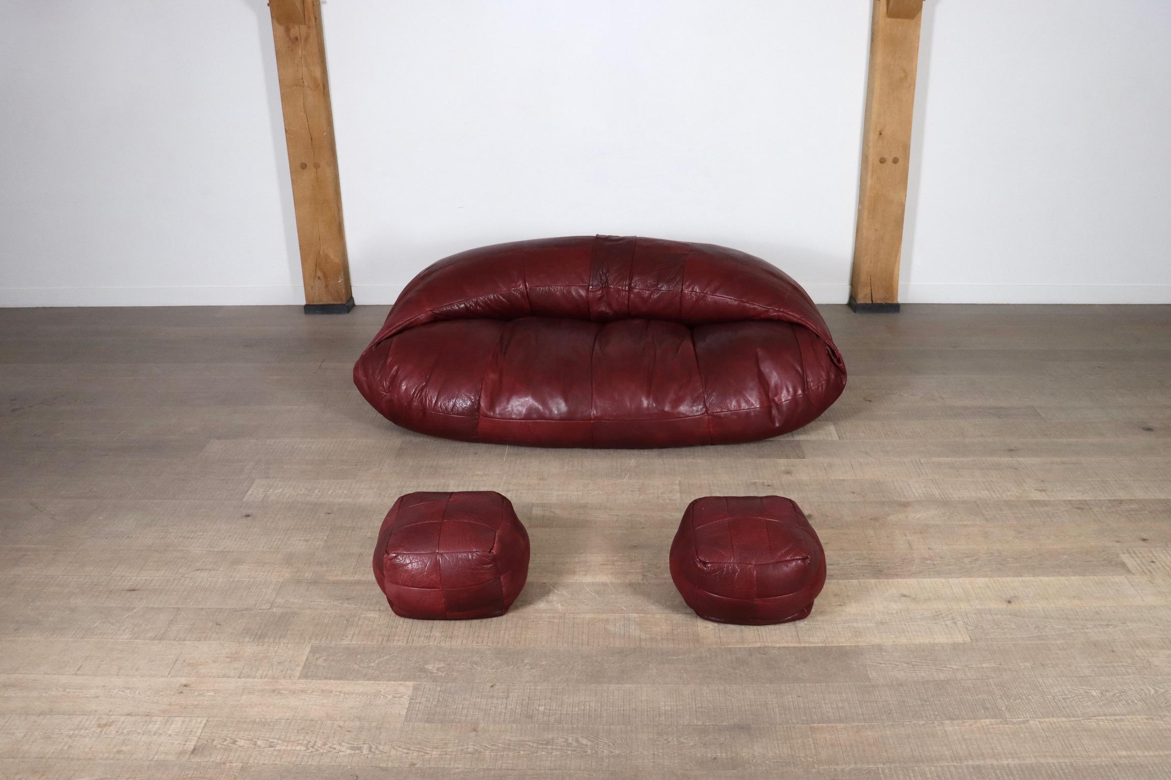 Amazing lounge sofa in original burgundy full grain leather with two poofs, designed by Raphael Raffel and produced by Honoré Paris in France in 1970.

A bespoke piece, which was made to order in the 1970s, in low numbers, which makes it a rare
