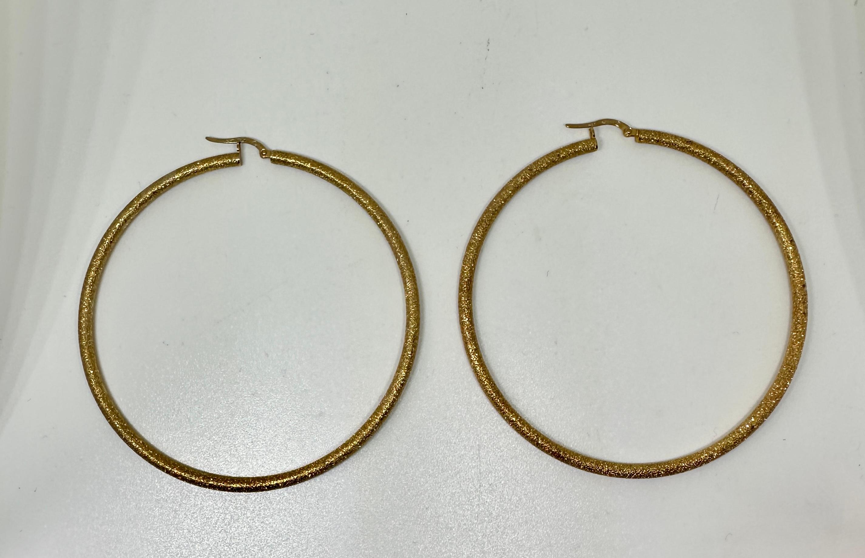 Concediti un paio di orecchini iconici e straordinari, provenienti dalla tenuta della leggendaria Icone.  Gli orecchini a cerchio sono in oro giallo 14 carati con una favolosa finitura Florentine spazzolata.  Gli orecchini sono lunghi ben 3 pollici.