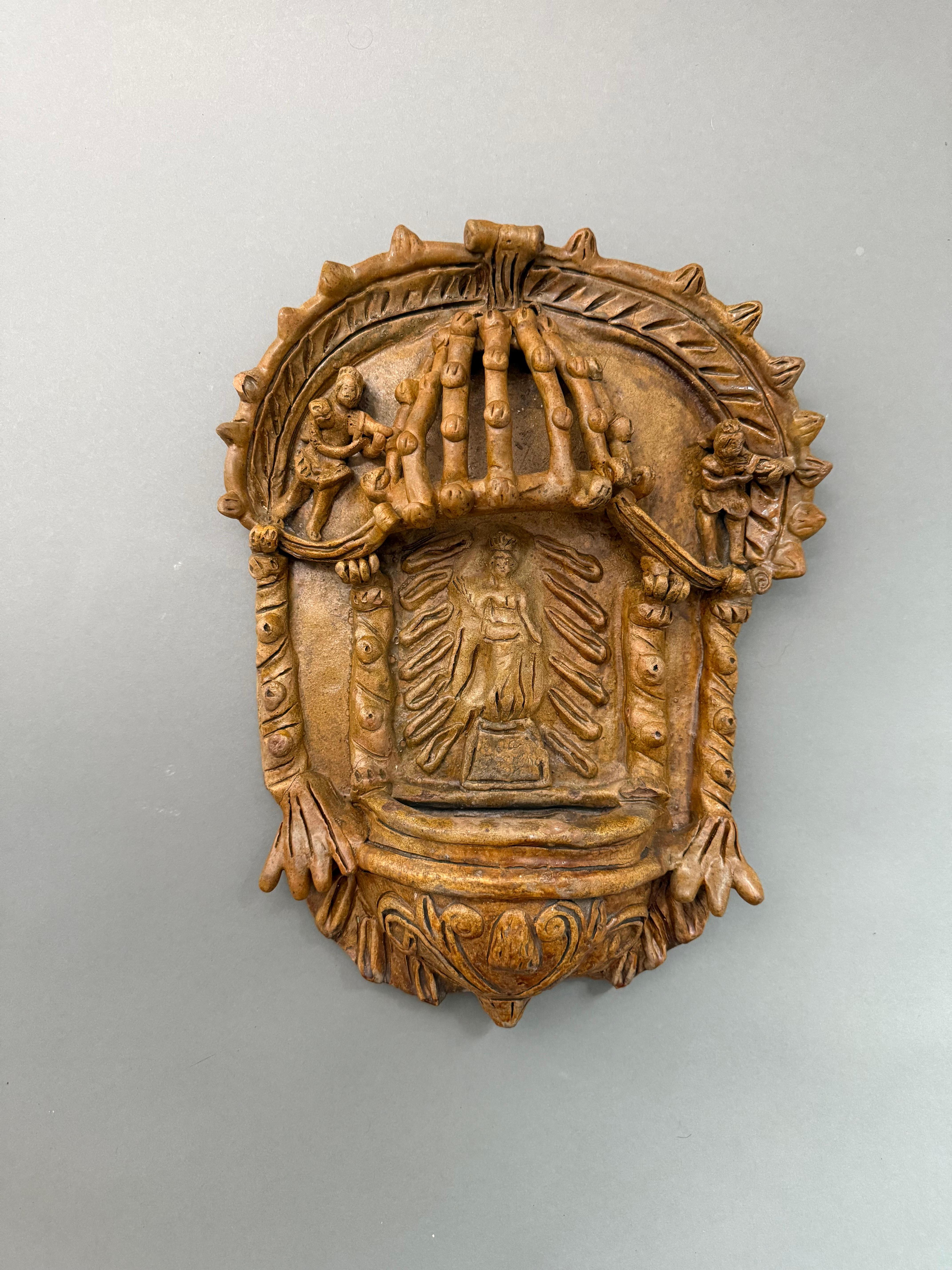 Rara acquasantiera ispano-moresca in terracotta del XVIII secolo. À l'intérieur de la niche, au centre, est représentée la figure de la Madone, assise sur une sorte de piedistallo et entourée d'éléments décoratifs qui proviennent des collections. 