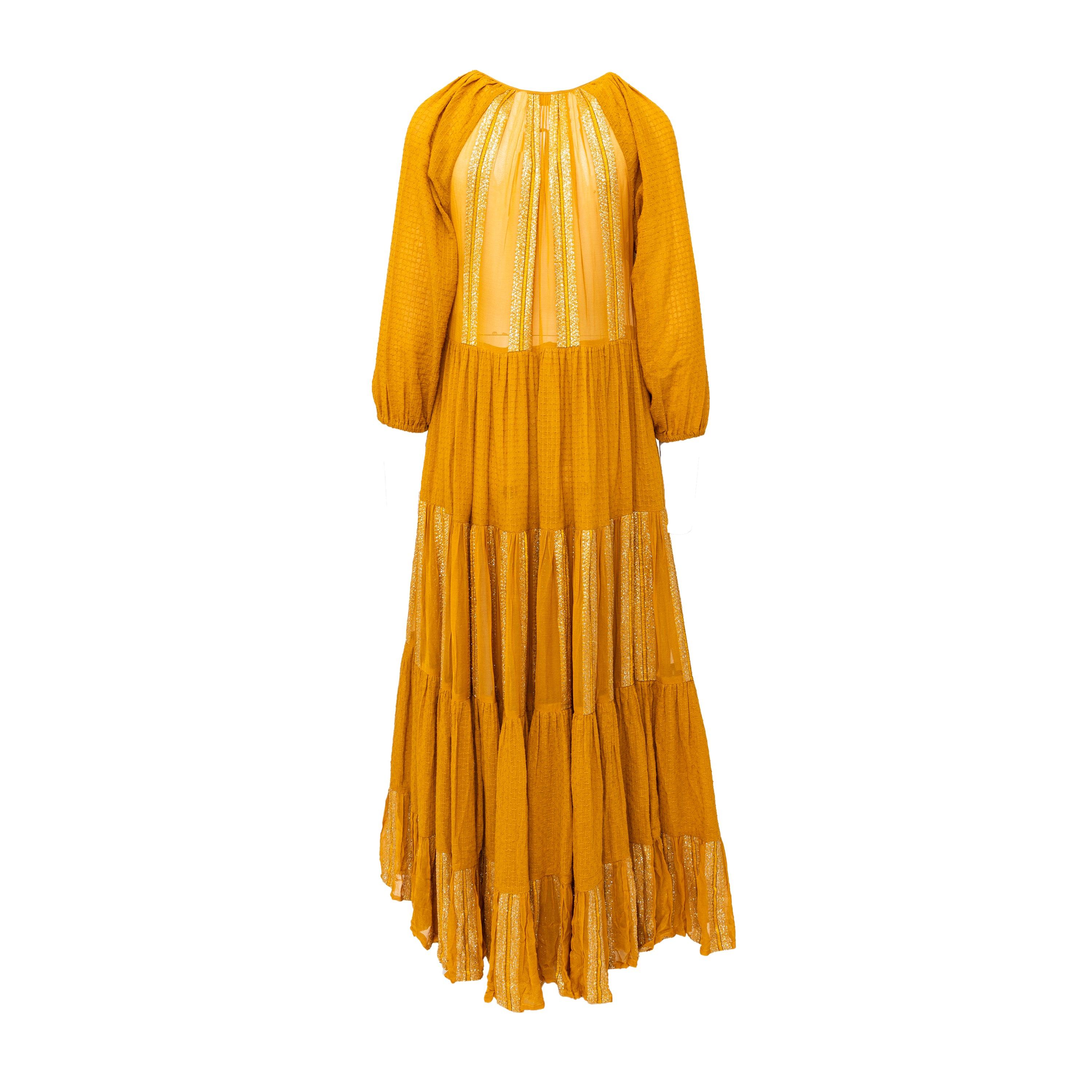 Effortlessly embody the bohemian spirit in the Rara Avis by Sonal Verma Boho Long Dress. Crafted from a luxurious cotton blend, this dress in a rich dark mustard yellow color features a v-neck with a tie-knot, relaxed shoulders. The long maxi style