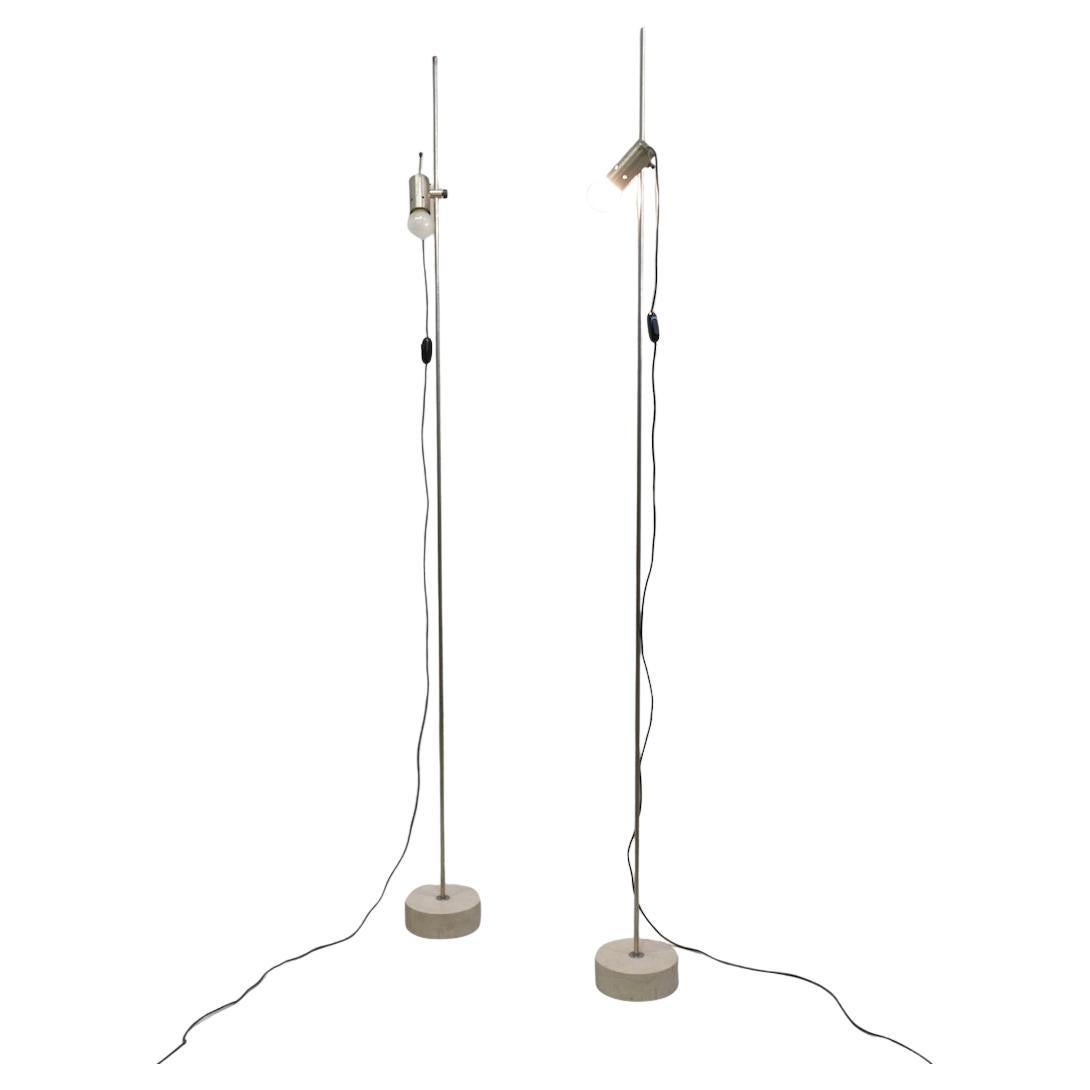 Pareja de lámparas de pie de Tito Agnoli para Oluce (Modelo nº 387), de metal niquelado y base de travertino.  Tito Agnoli fue un diseñador italiano conocido por su enfoque innovador y minimalista del diseño de mobiliario e iluminación. Nacido en