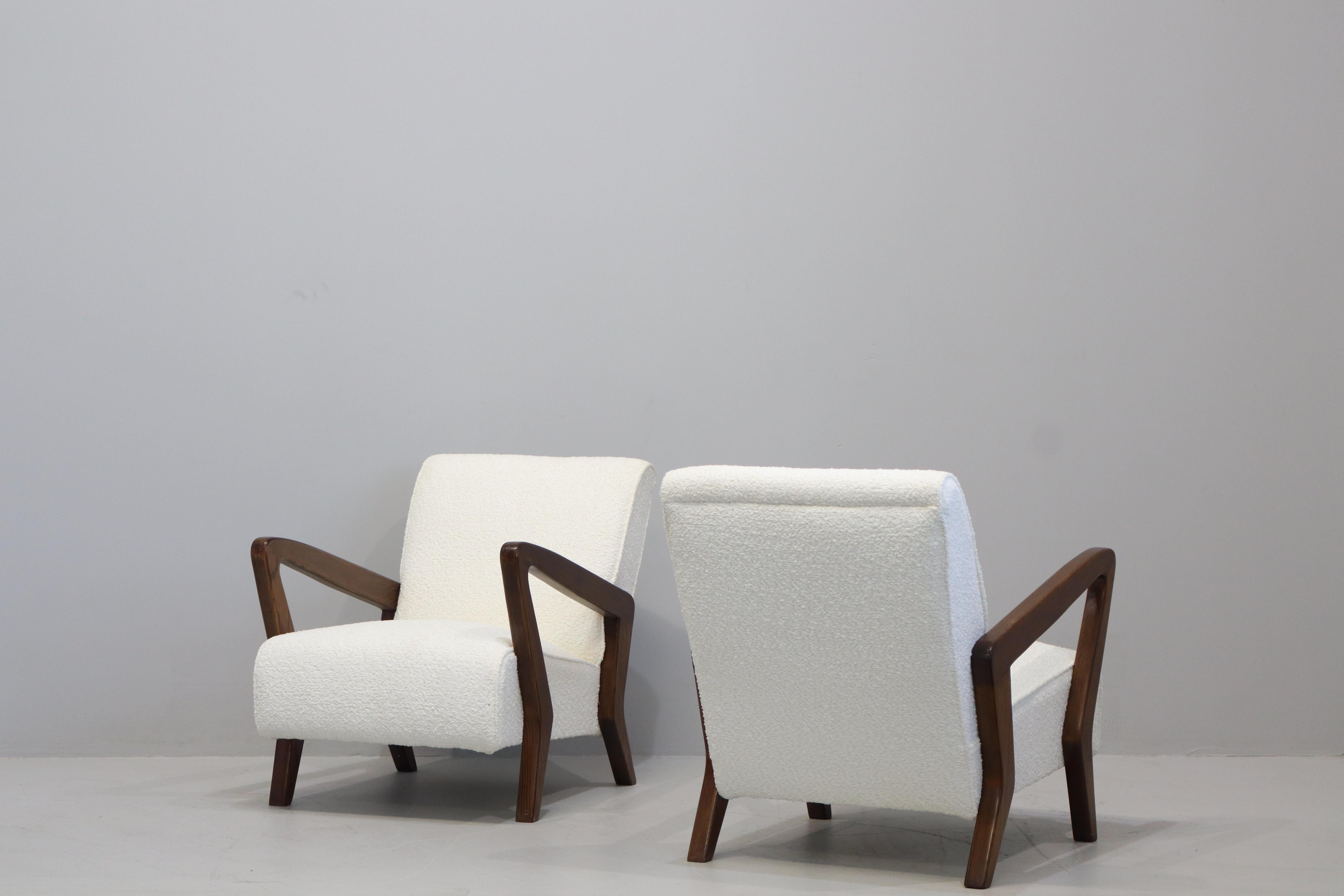 Rara e sofisticata coppia di poltrone  italiane di metà secolo provenienti da un'importante villa di Bologna. 
Disegnate da Gio Ponti, boucle  e legno, anni '50  Il legno è stato lucidato dai nostri restauratori, che hanno rivestito le sedie in