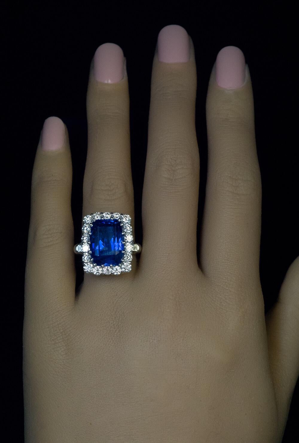 An 11.51 ct old mine cut Ceylon sapphire of a vivid blue color is set in a modern platinum and diamond ring.  The diamonds are bright white and clean: F-G color, VS clarity. Total diamond weight is 1.61 ct.  The sapphire and diamond cluster measures