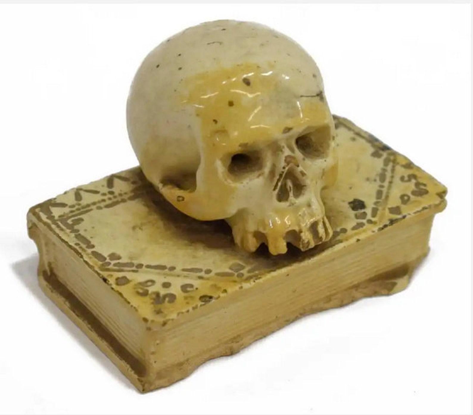 A scarce Italian ceramic Memento Mori, circa 1550, in the form of a human skull resting on a book.

Memento Mori is a Latin term that translates to “remember that you will die,” and has been illustrated in numerous works of art. While the