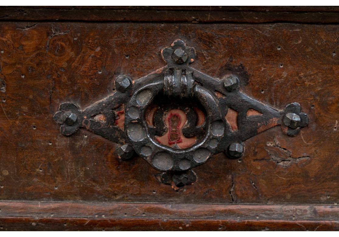 A 17th/ 18th century Spanish buffet with four drawers flanking a central door all decorated with fabric backed iron fretwork and hammered ring pulls and side handles. The cabinet raised upon shaped feet with spool legs with a twisted iron stretcher
