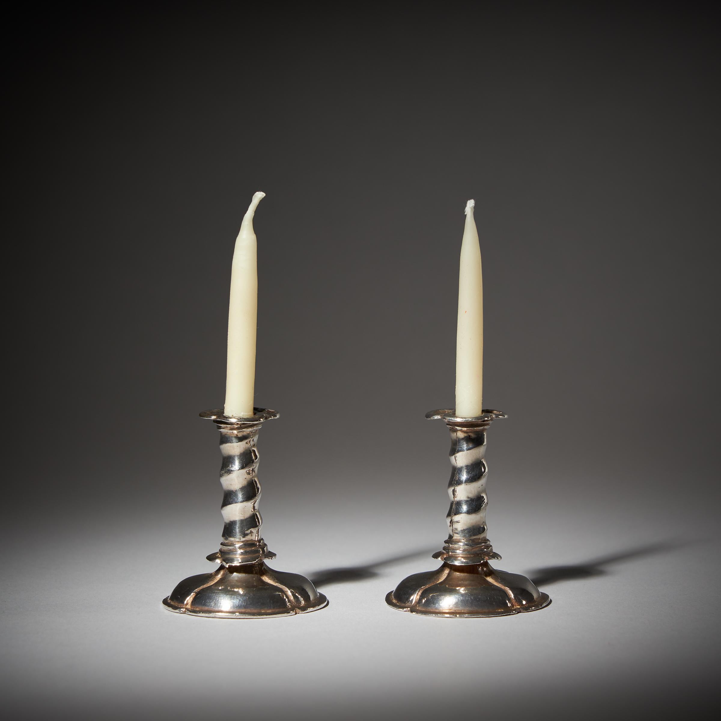 An extremely rare pair of 17th century cast miniature trumpet form silver candlesticks from circa 1660. England. 

Each candlestick is raised on a sectioned trumpet base, Solomonic twist column with a quatrefoil drip pan and topped with a lipped