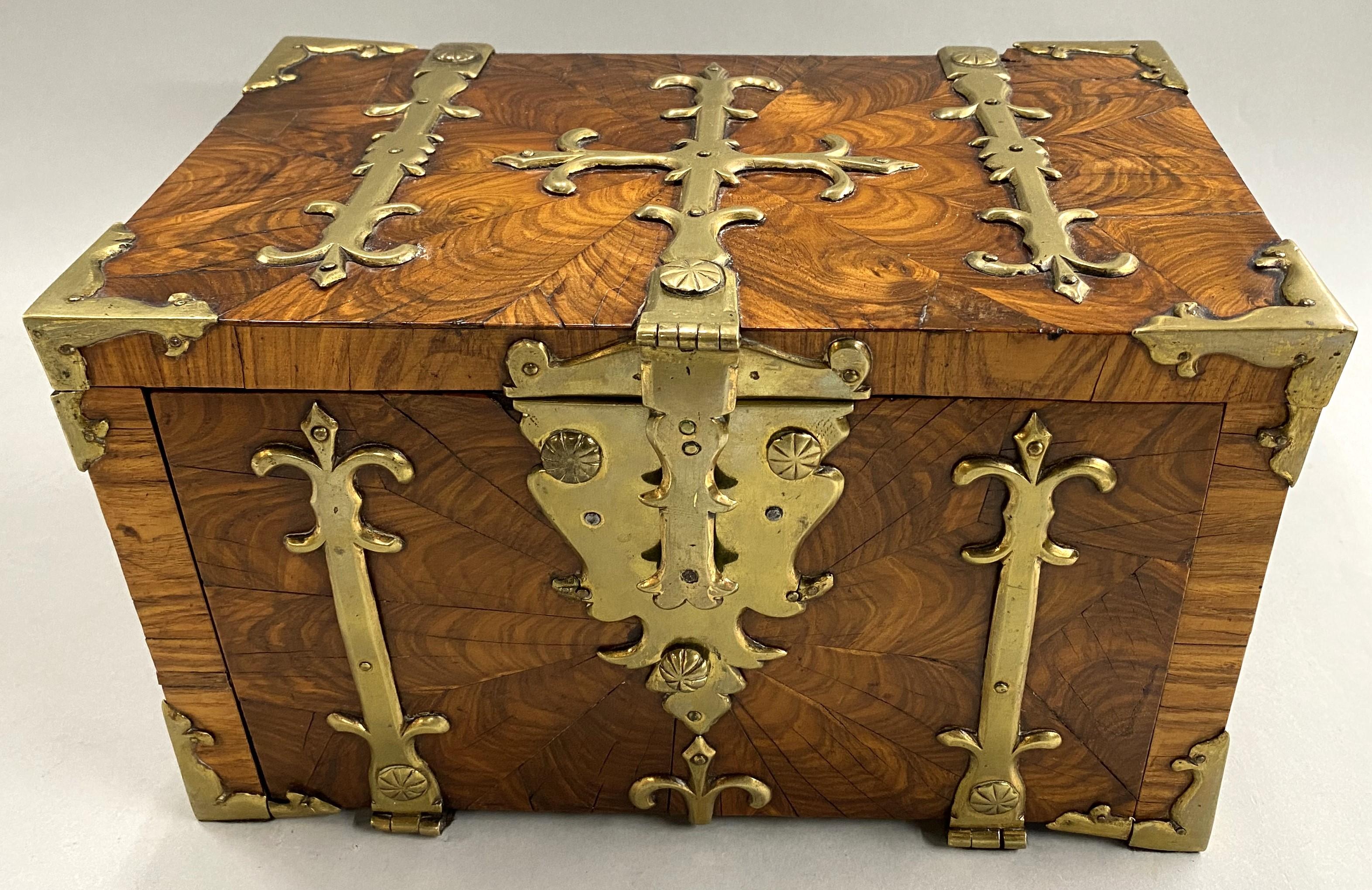 A rare English coffre fort or strong box of princeswood (later known as kingwood) with brass strapping and side handles. The front opens to reveal one hidden drawer. The lock and key are original, as well as all the brass on the box. Dates to circa