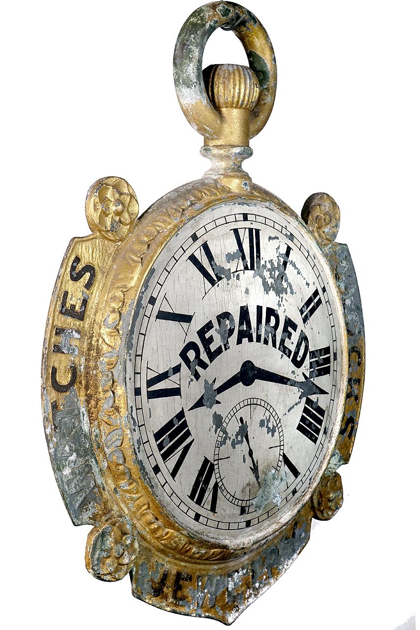 This impressive 19th century antique American outdoor storefront hanging jeweler or watchmaker trade sign is attributed to the Miller Co., Bellefontaine, OH. Visually striking and double-sided the pocket watch advertising sign features an ornamental