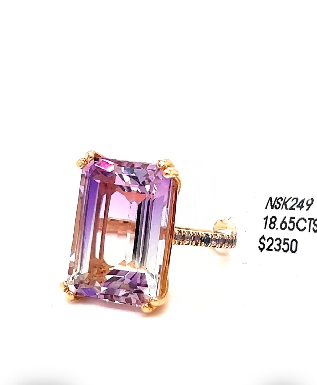 Rare and amazing Bi color emerald amethyst gem combination of pure white down to deep purple combined in this magnificent 18.65 carat gem stone.
Setting is a 14k solid rose gold with micro pave tanzanite rounds on both sides of its shank.